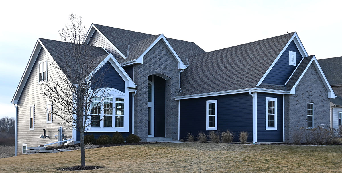 Custom exterior home painting project in Menomonee Falls WI with dark blue siding