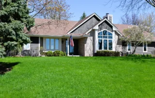Exterior painting project on Alta Vista Dr in Sussex WI featuring refreshed siding, white trim, stone accents, gables, and a green front lawn.