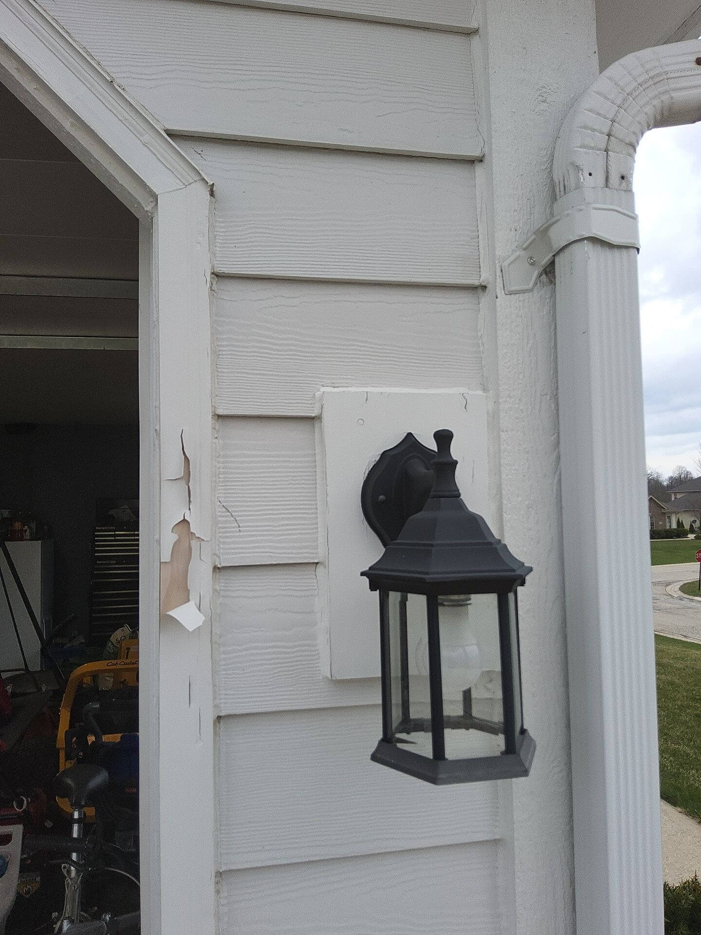 Peeling exterior paint near garage trim on a Germantown WI home before preparation