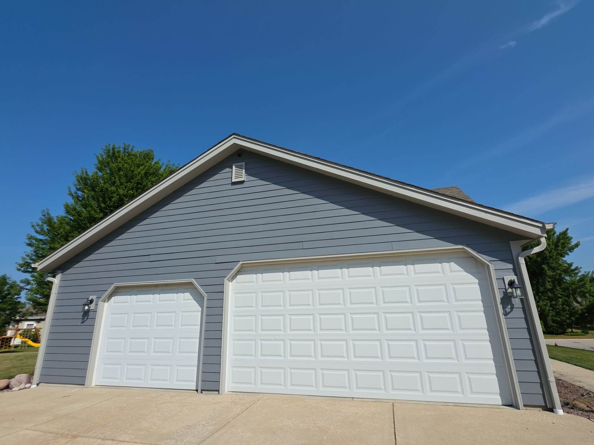 Painted garage exterior with blue-gray siding and white trim in Germantown WI