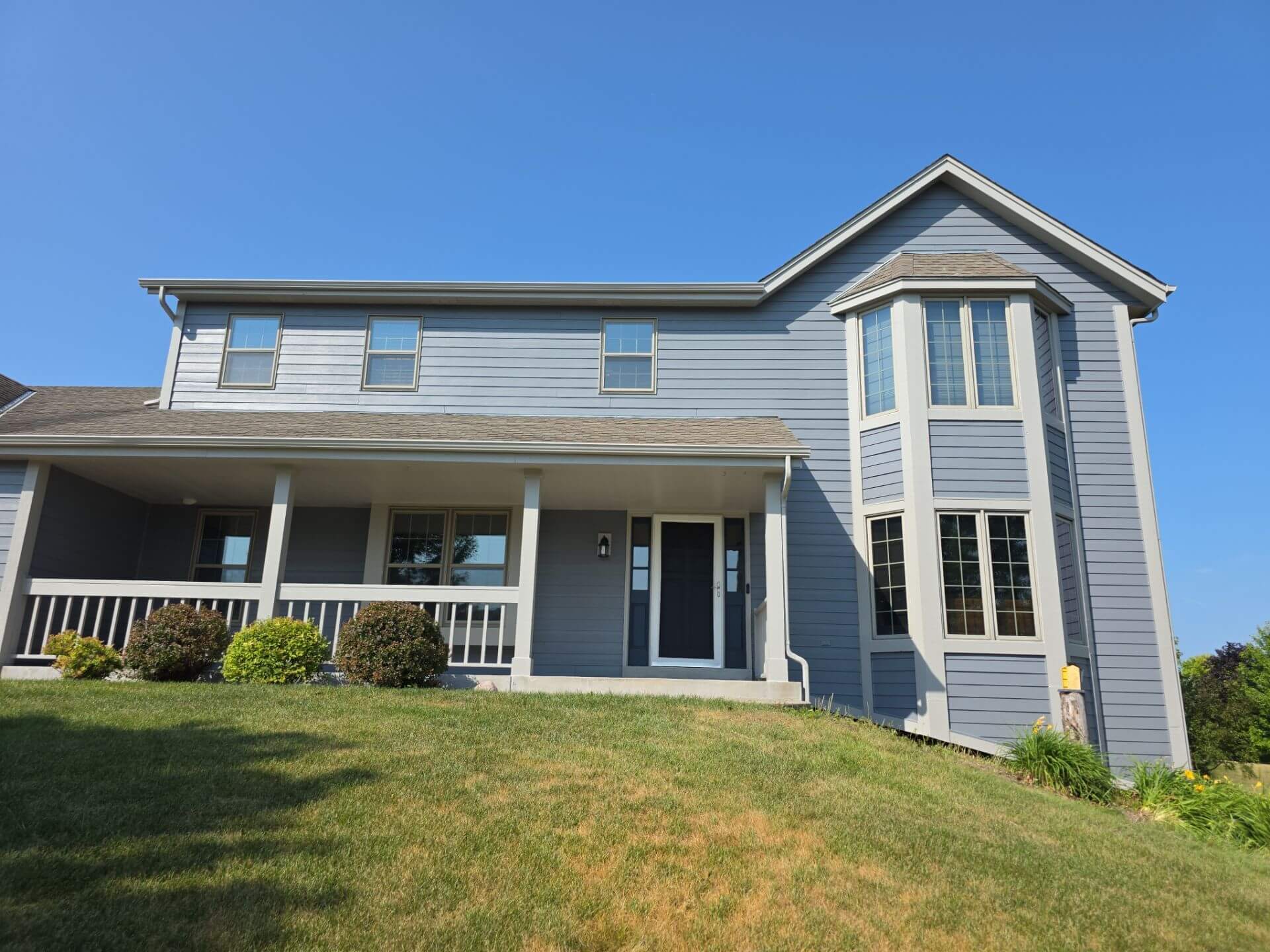 Completed Germantown WI exterior painting project with blue-gray siding and white trim