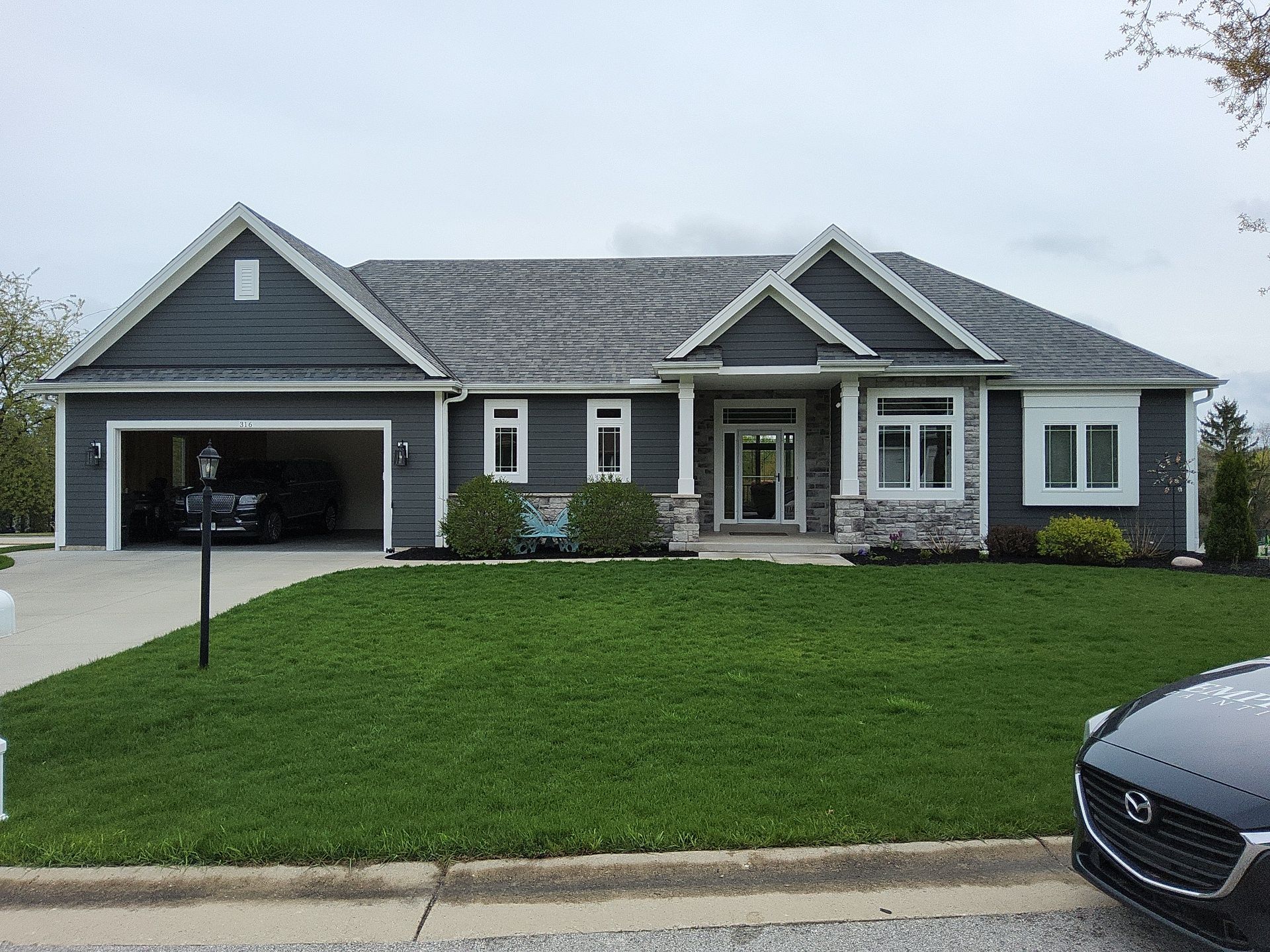 Wales home with charcoal-gray siding, white trim and stone accents