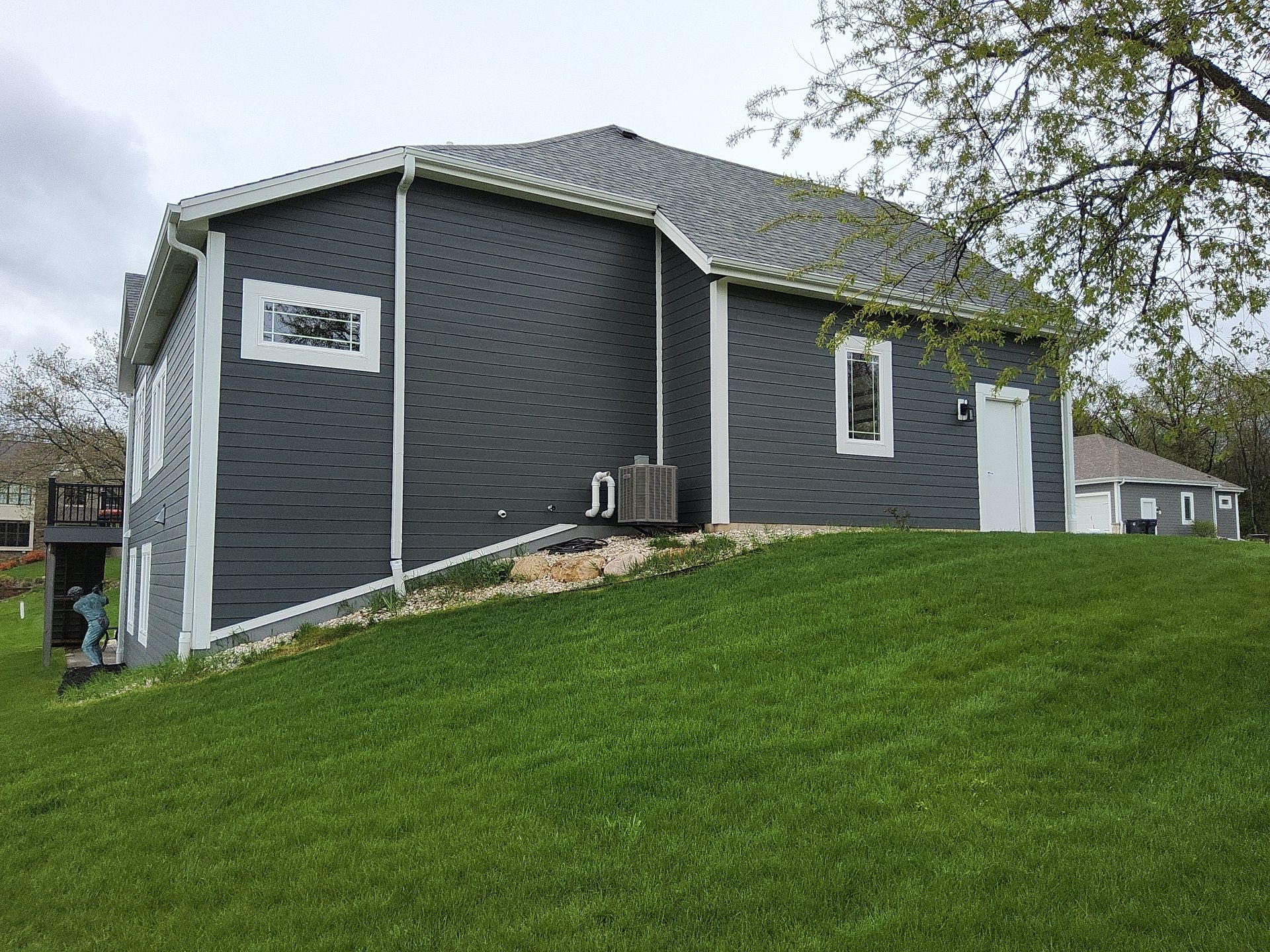 Side and rear exterior with charcoal siding and white trim in Wales, Wisconsin
