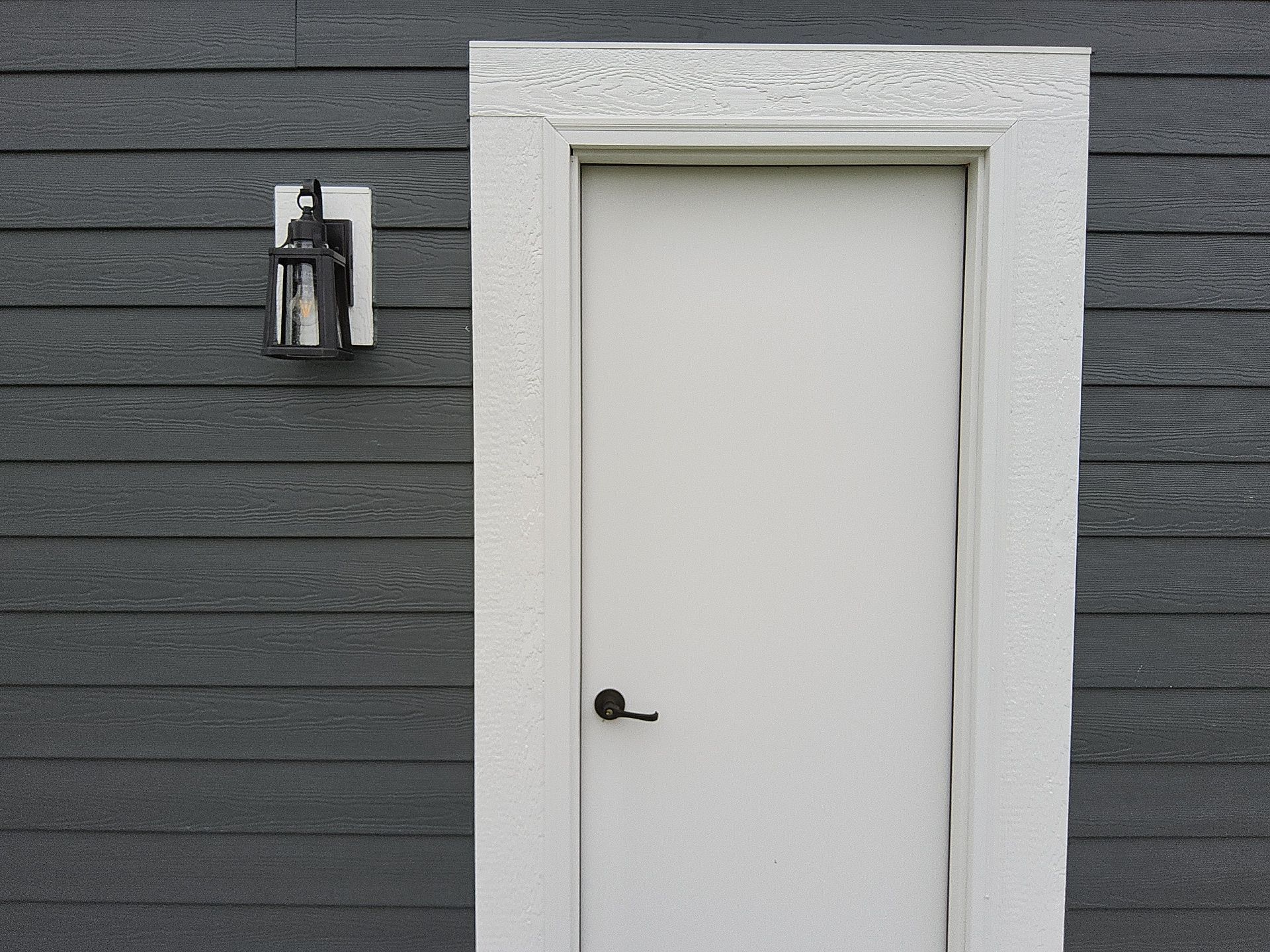 White side door and trim against charcoal siding in Wales, Wisconsin