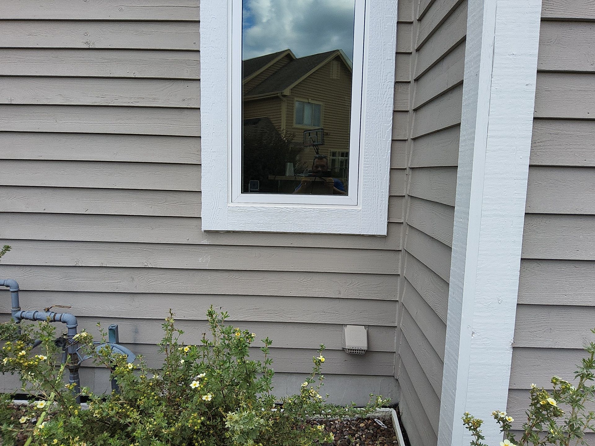White window and corner trim against taupe siding in Nashotah