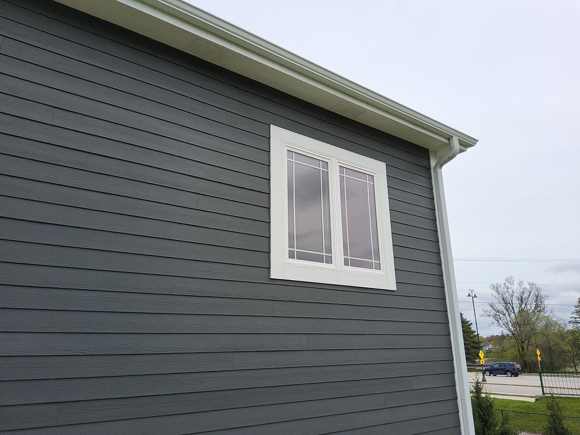 Charcoal siding with a white-trimmed double window in Wales, Wisconsin