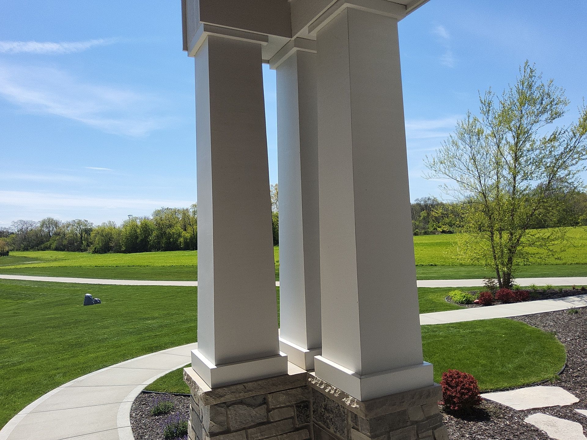 Close view of white painted porch columns and stone bases