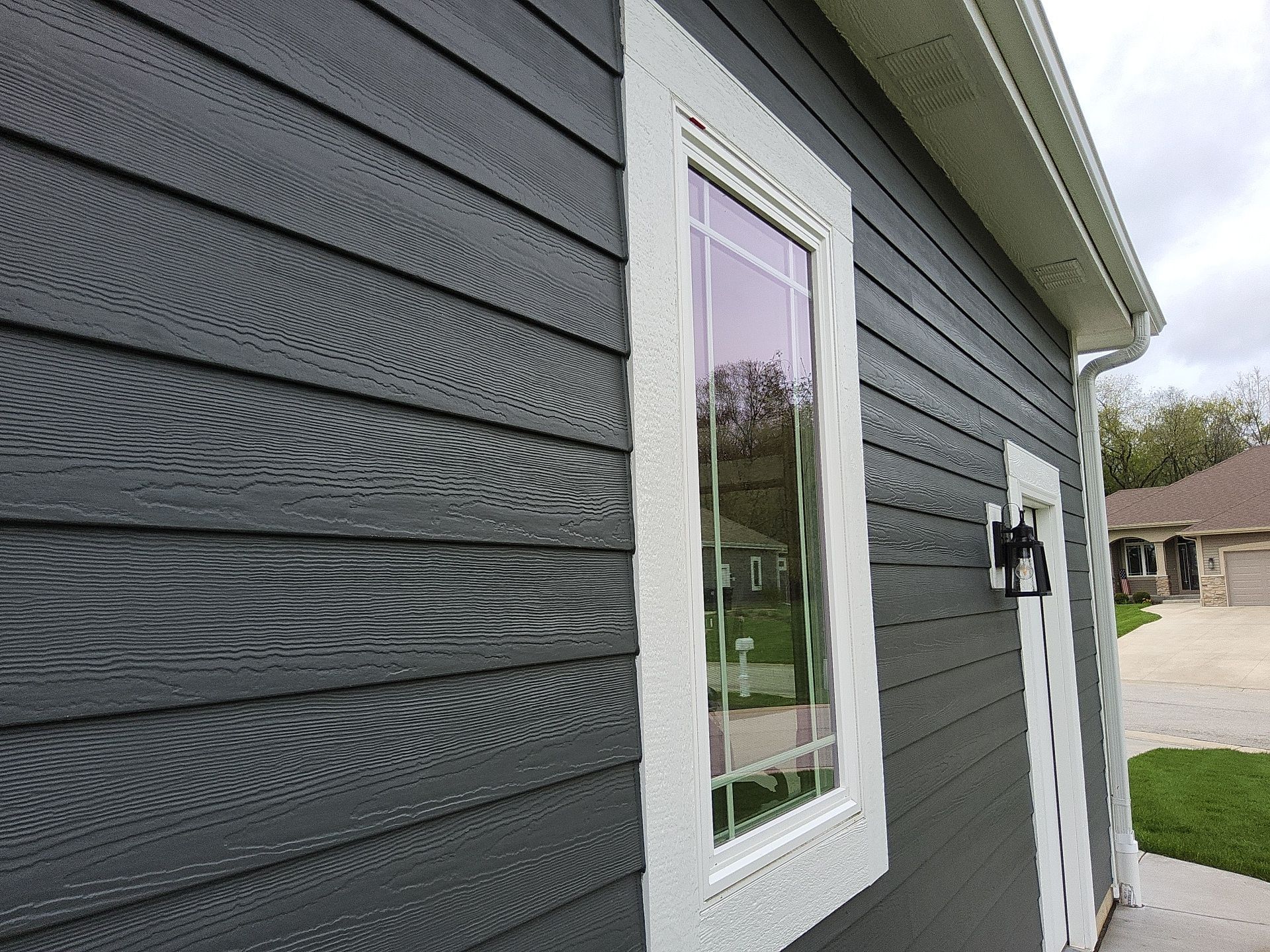 Charcoal siding and a tall white-trimmed window in Wales, Wisconsin