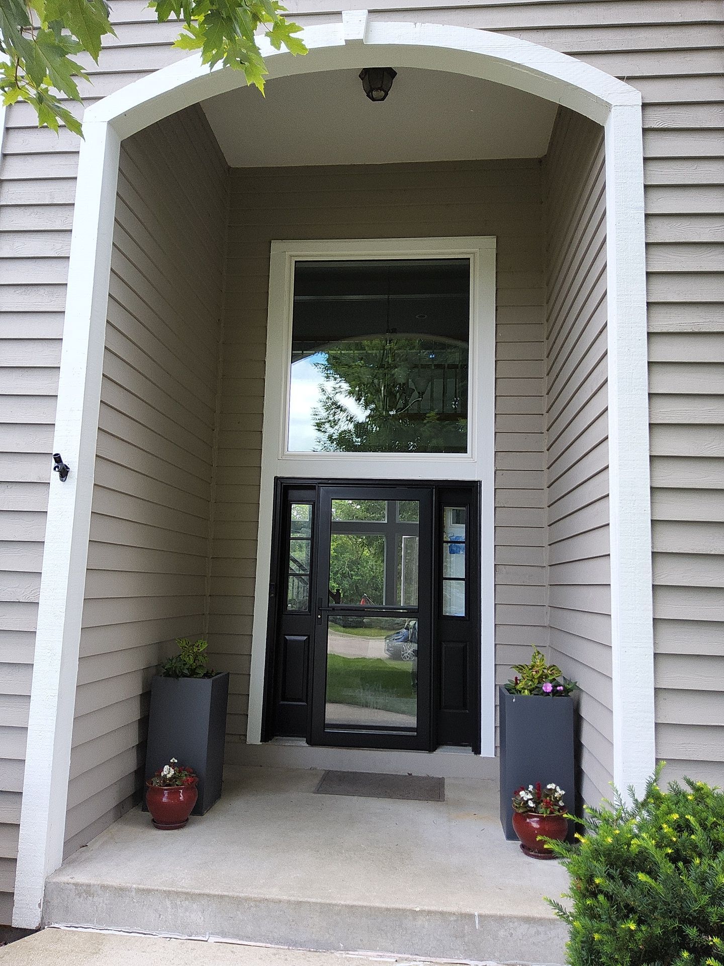 White arched entry trim surrounding a dark door at the Nashotah home