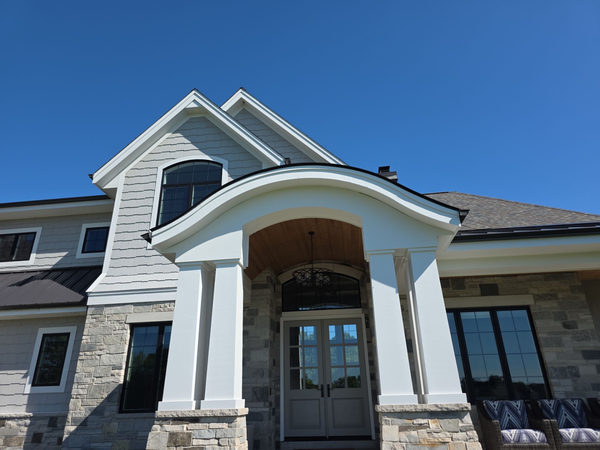 New Berlin home with a curved front entry, white columns and light gray exterior details