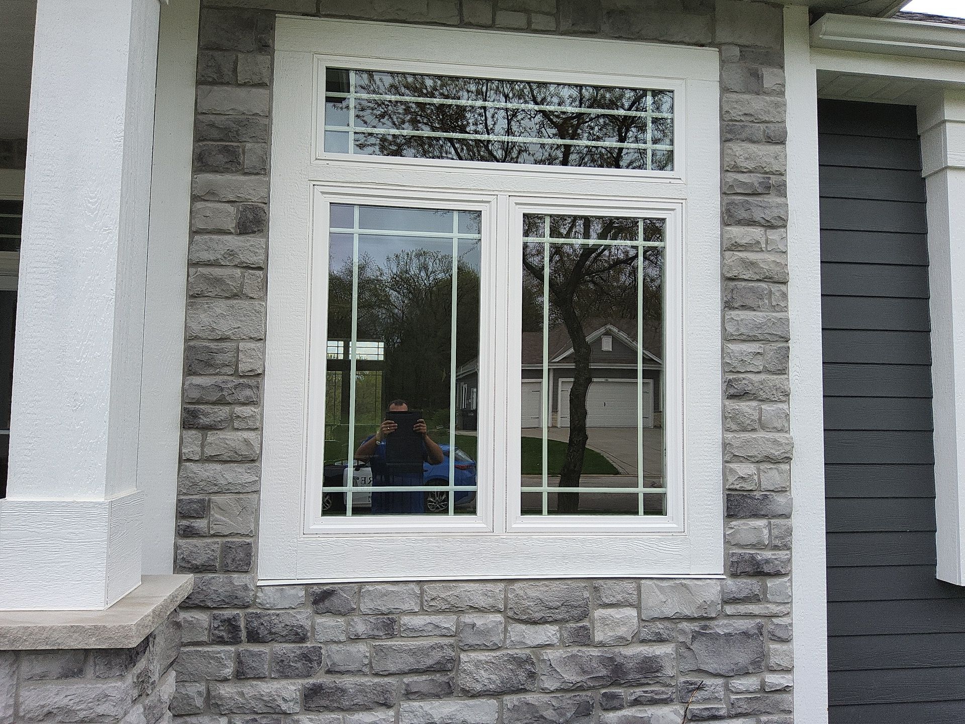 White front window trim surrounded by stone in Wales, Wisconsin