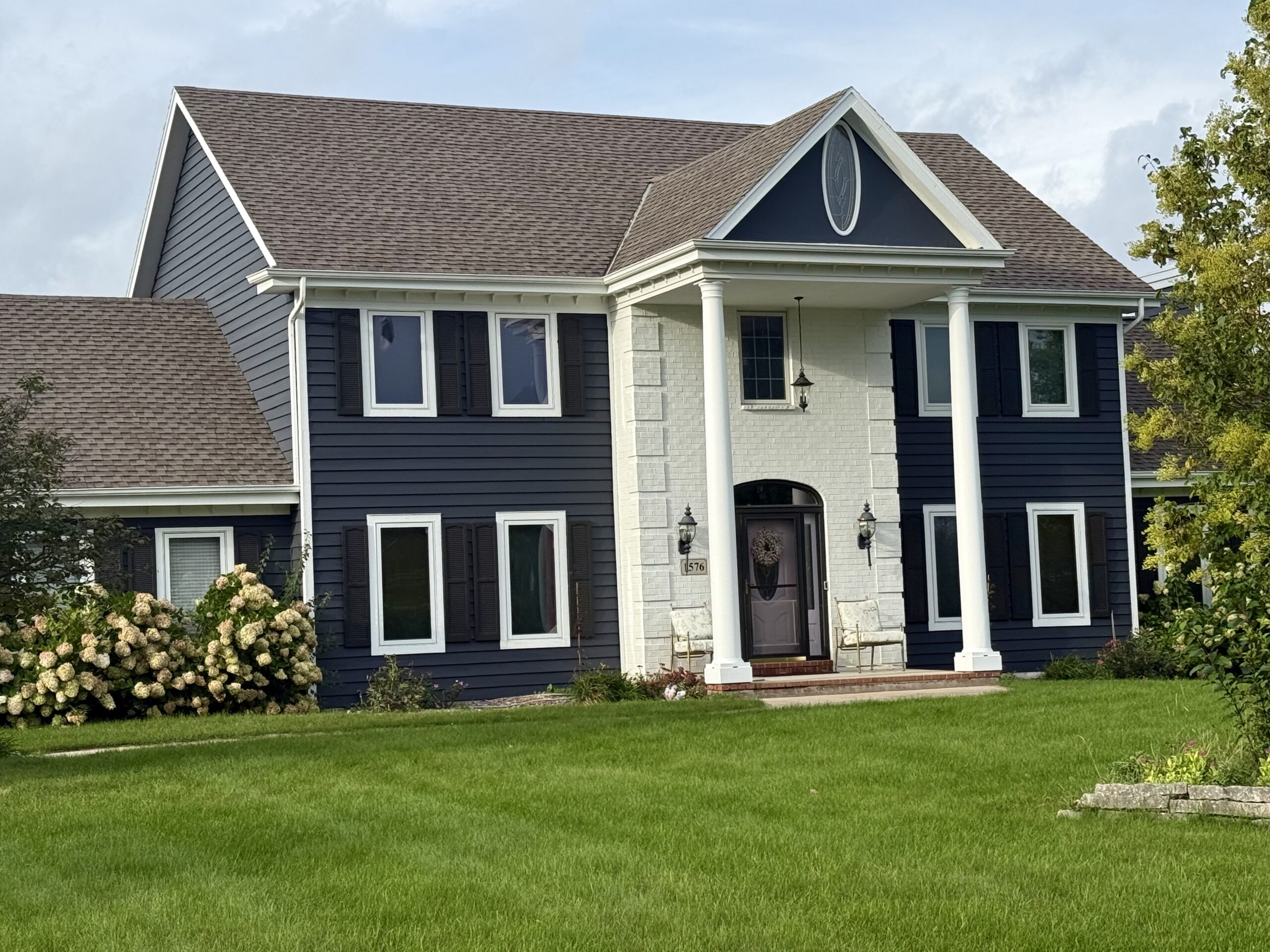 Navy blue Wolf Run home with white trim and columns in Richfield, Wisconsin