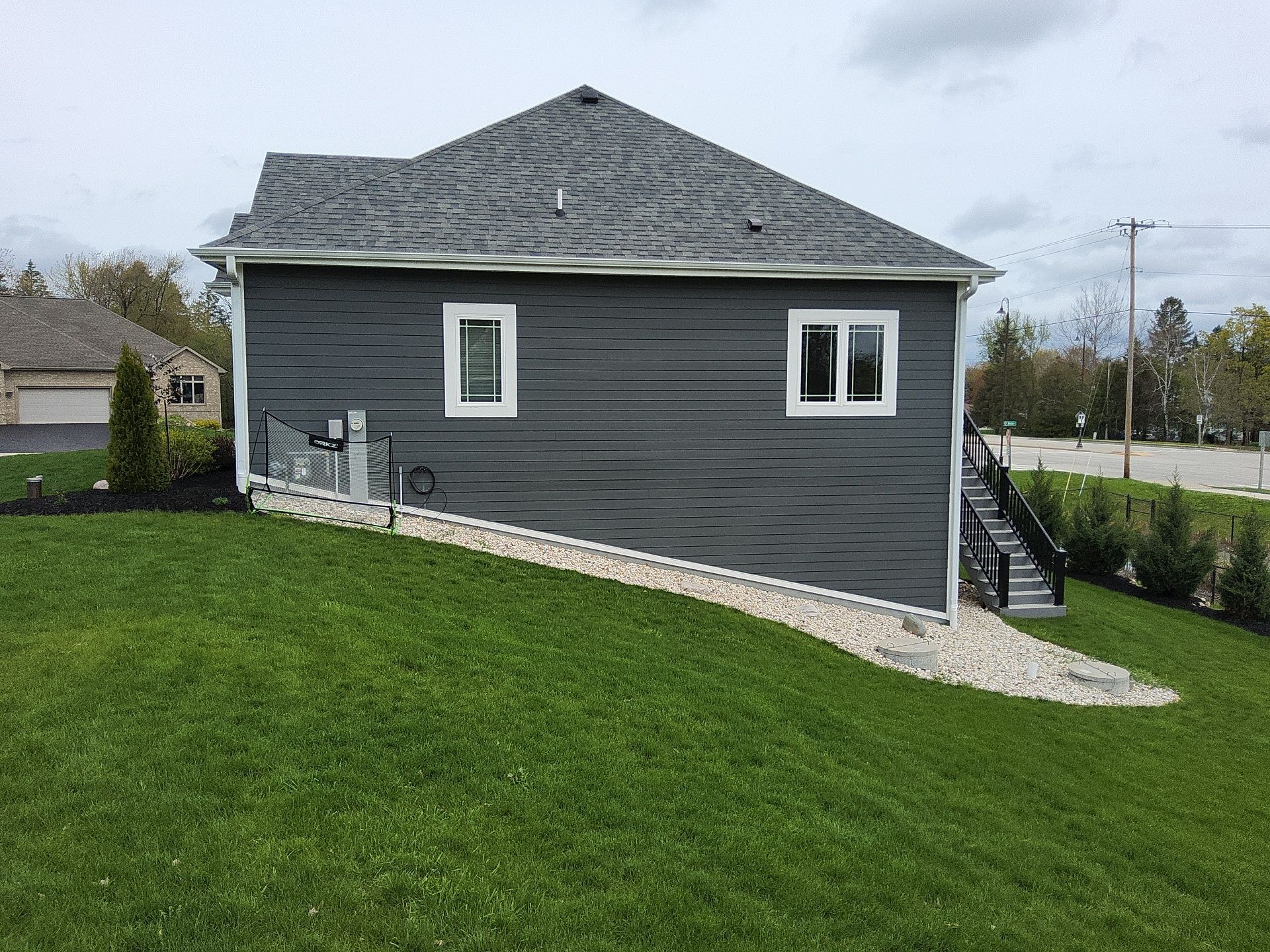Side elevation with charcoal siding and white window trim in Wales, Wisconsin