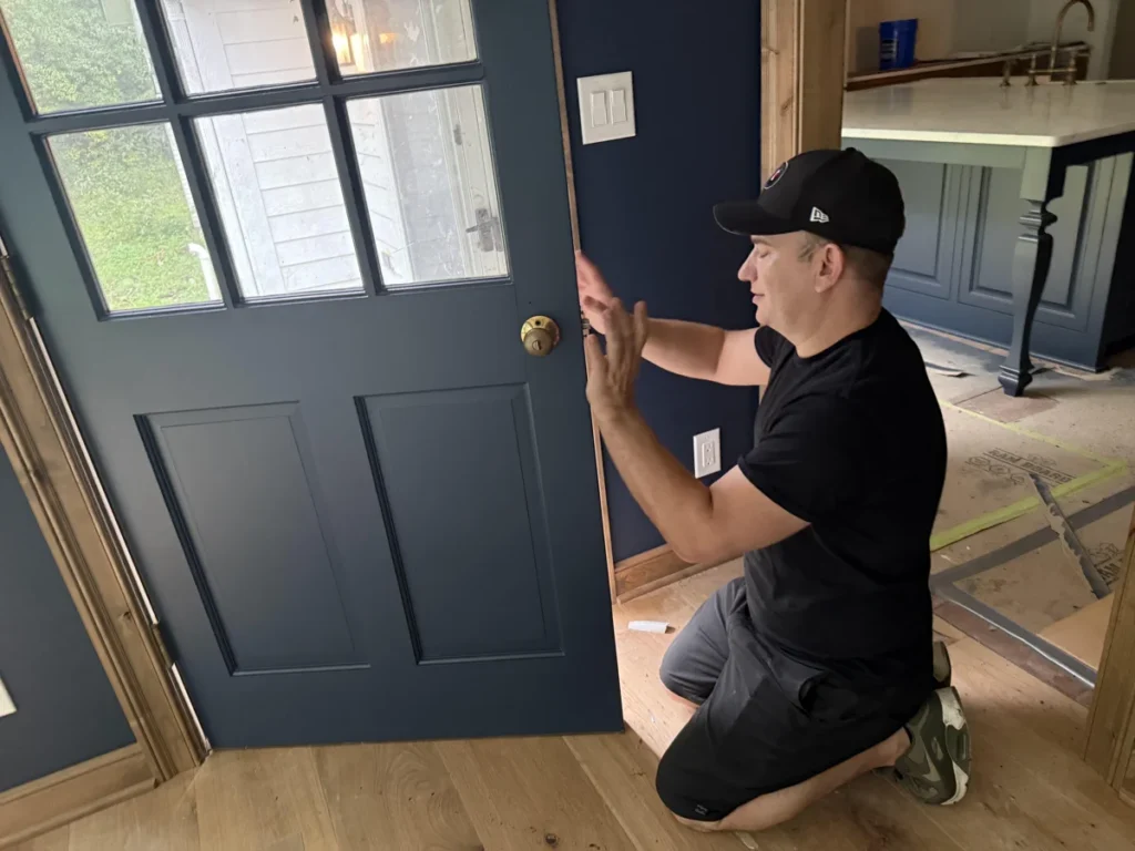 Dan Brooks, owner of Empire Painting, on site beside a blue painted door