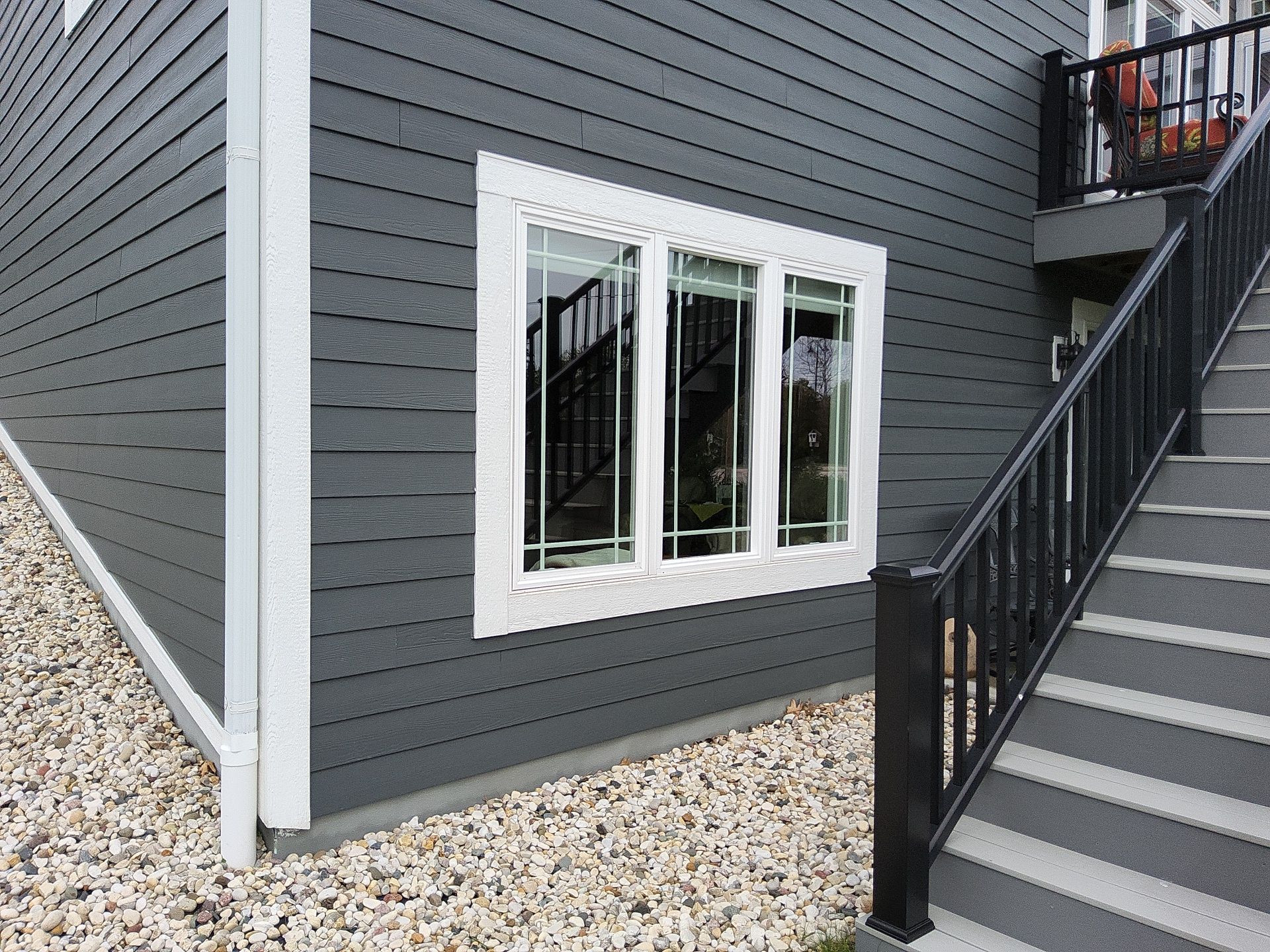 Lower-level window trim beside deck stairs in Wales, Wisconsin