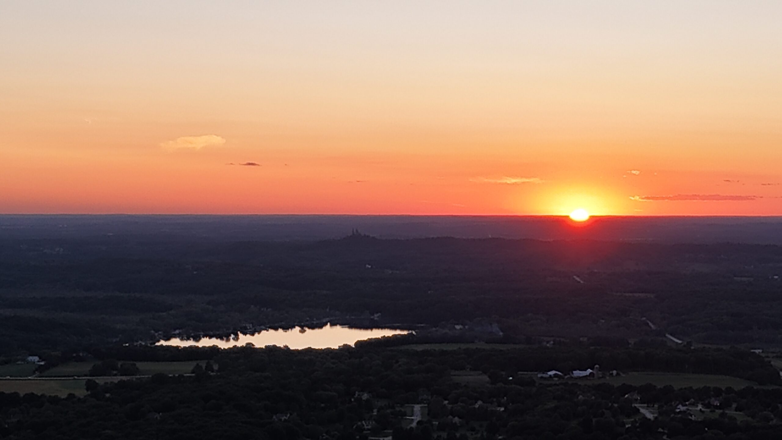 Sunset over the Richfield area, with Holy Hill visible on the distant wooded horizon.
