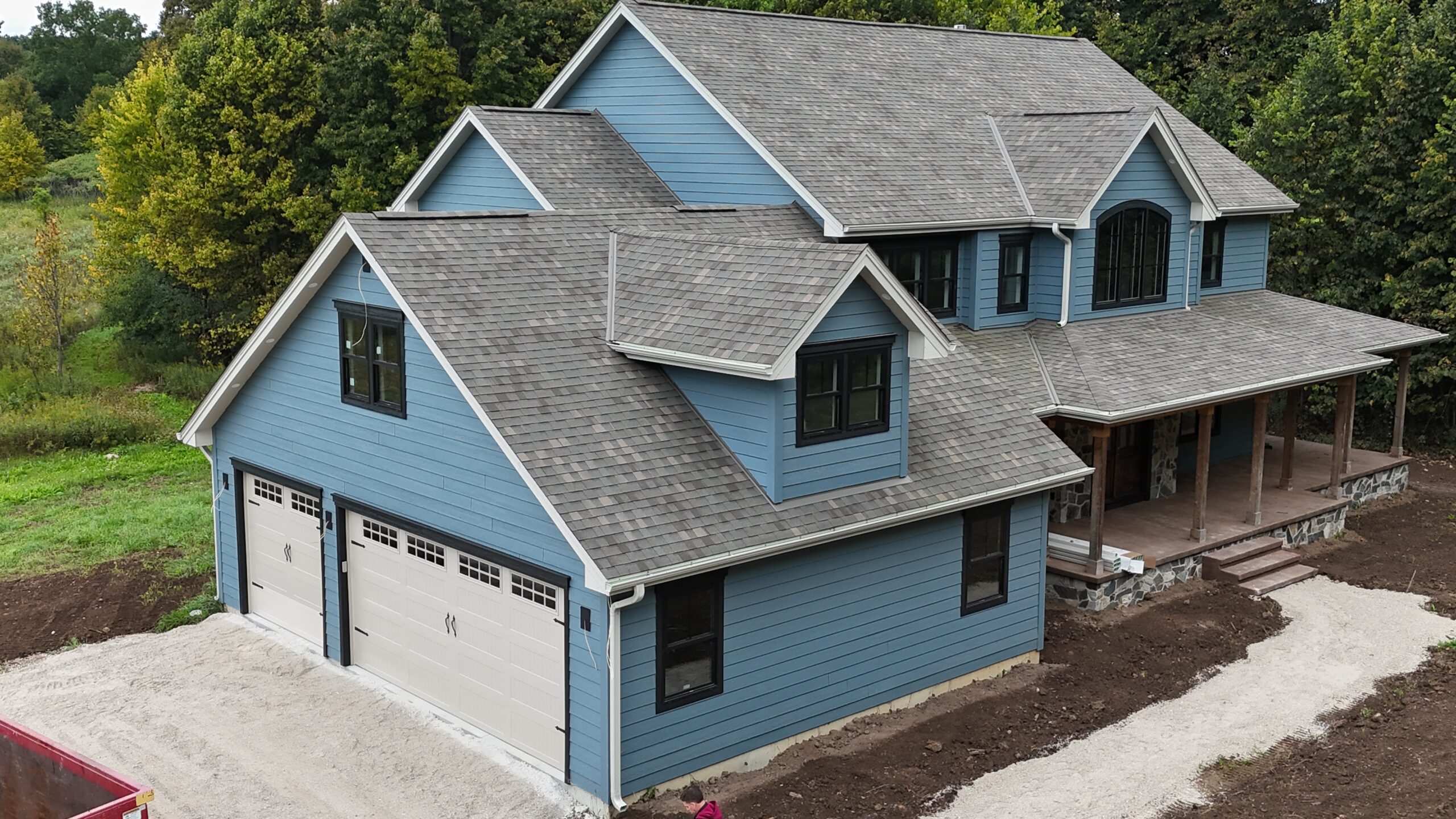 Aerial view of a Richfield new construction home with blue siding and covered porches