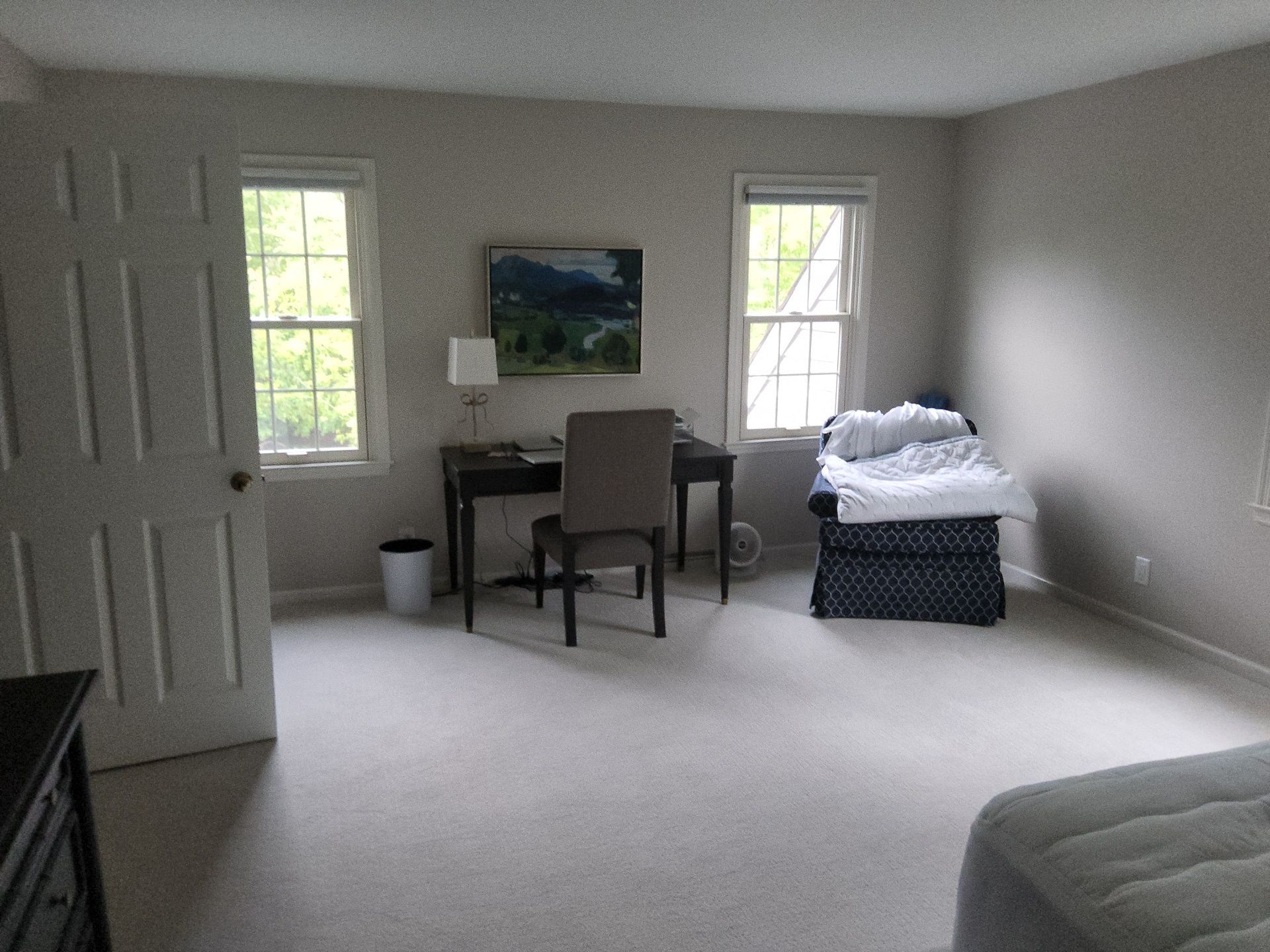 Spacious Mequon bedroom with light walls, white trim and large windows