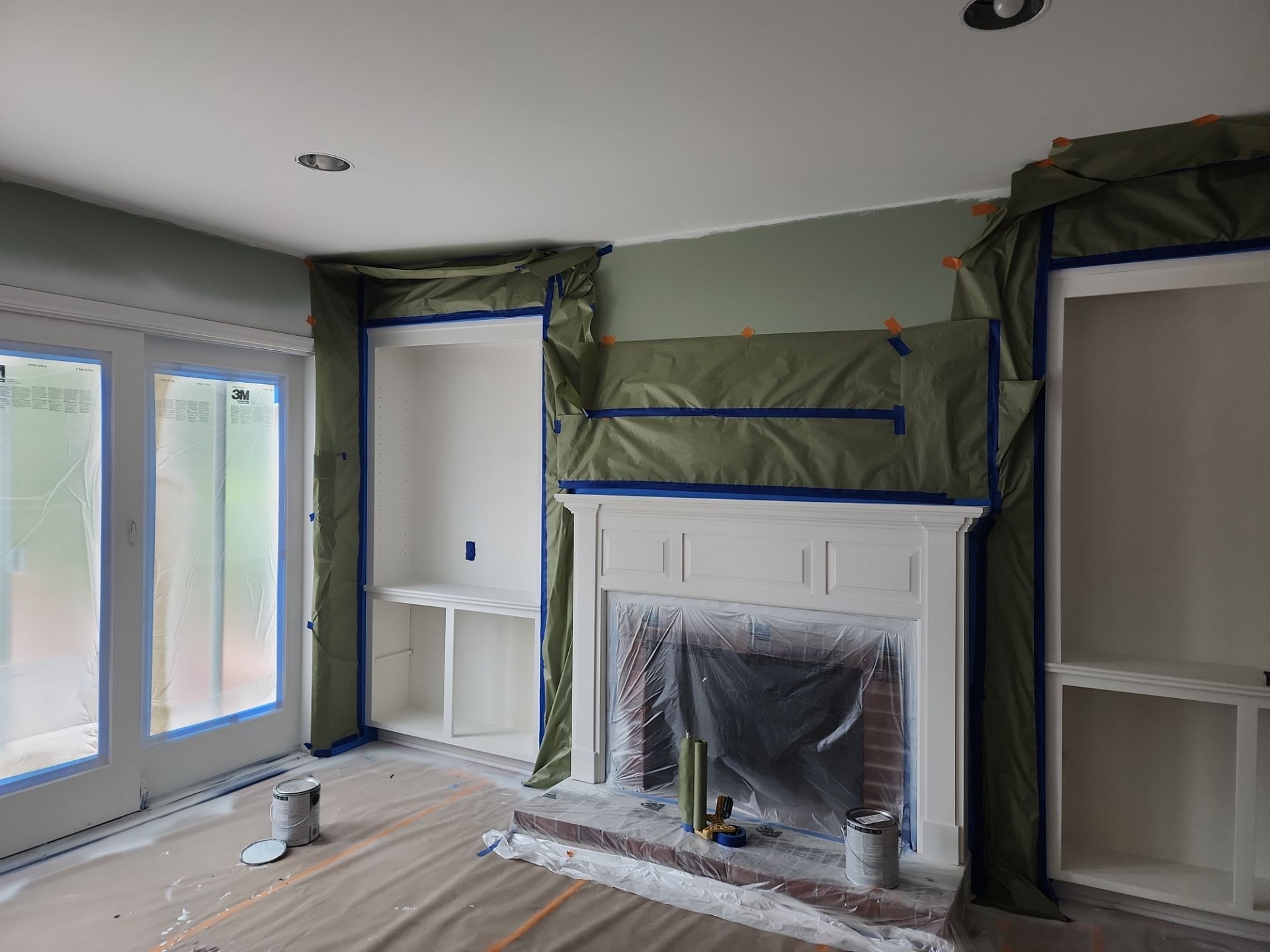 Fireplace and built-ins protected for painting in a Mequon home