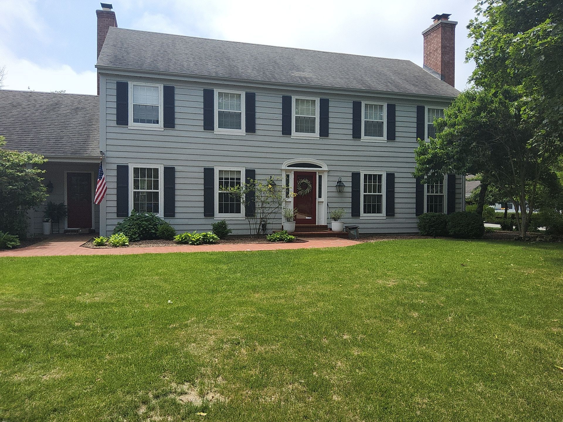 Mequon home on White Oak Way with light siding and dark shutters