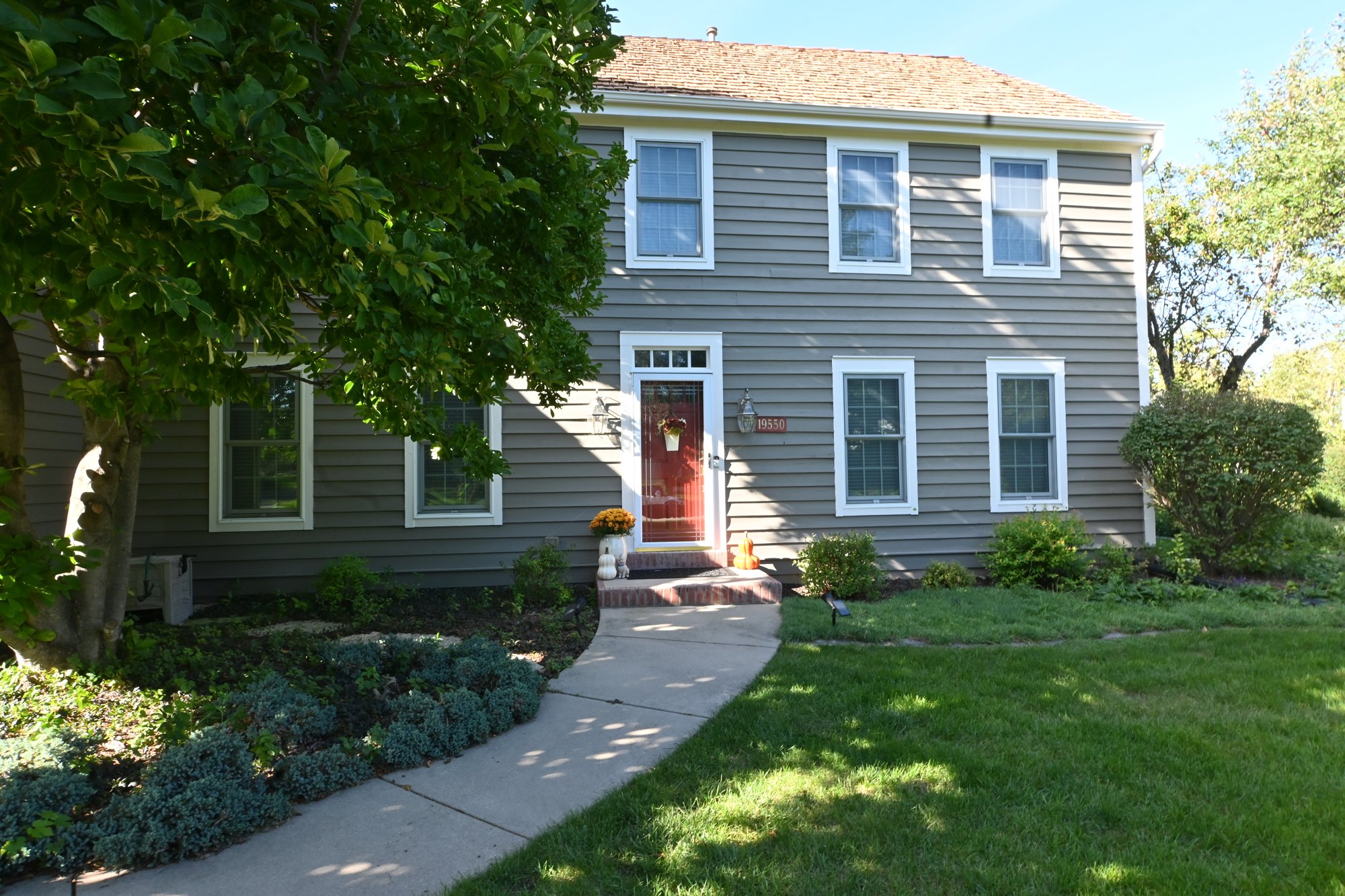 Brookfield home front entry framed by gray siding and white window trim