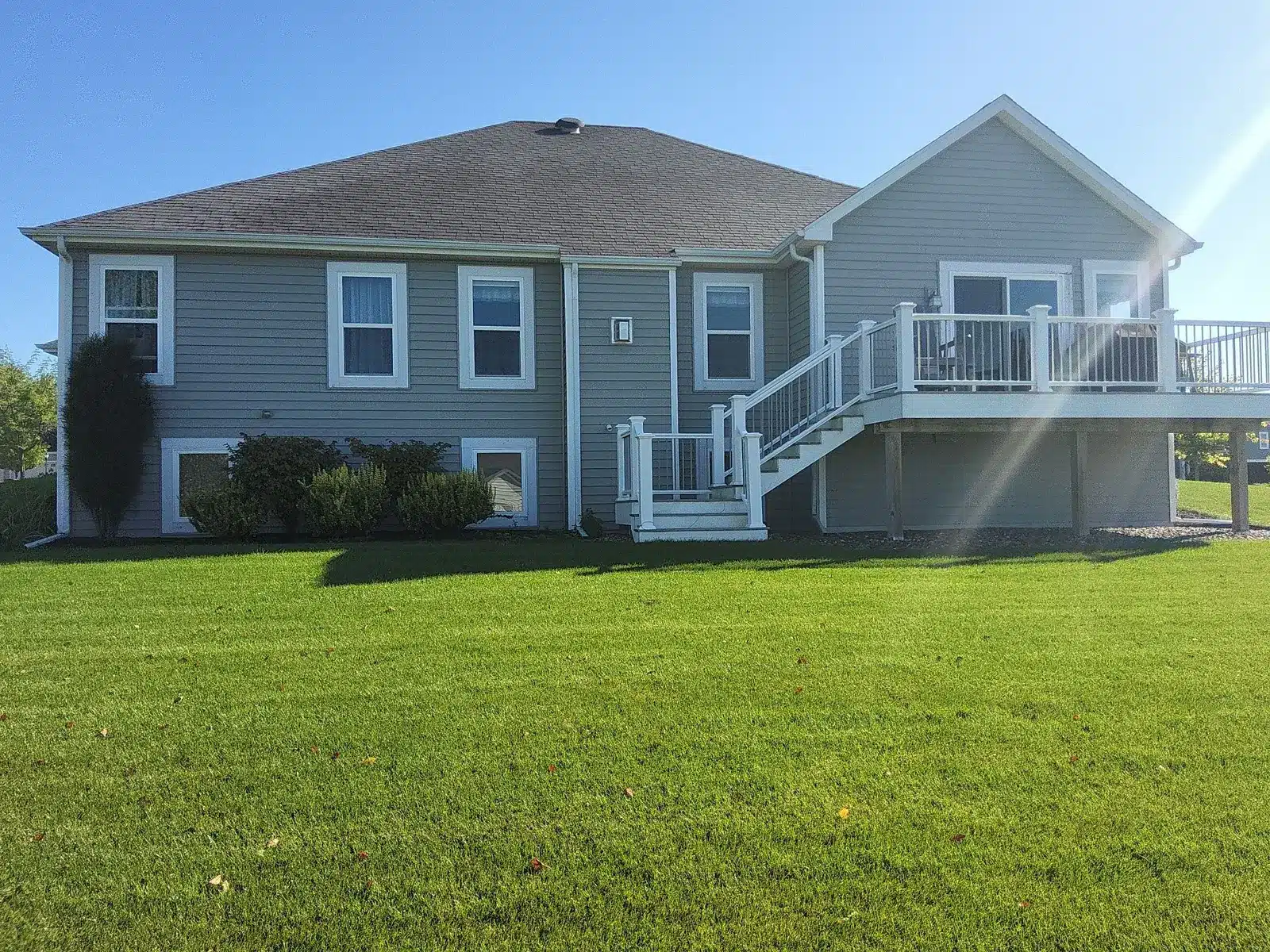 Rear home exterior with white deck and stairs in Mukwonago