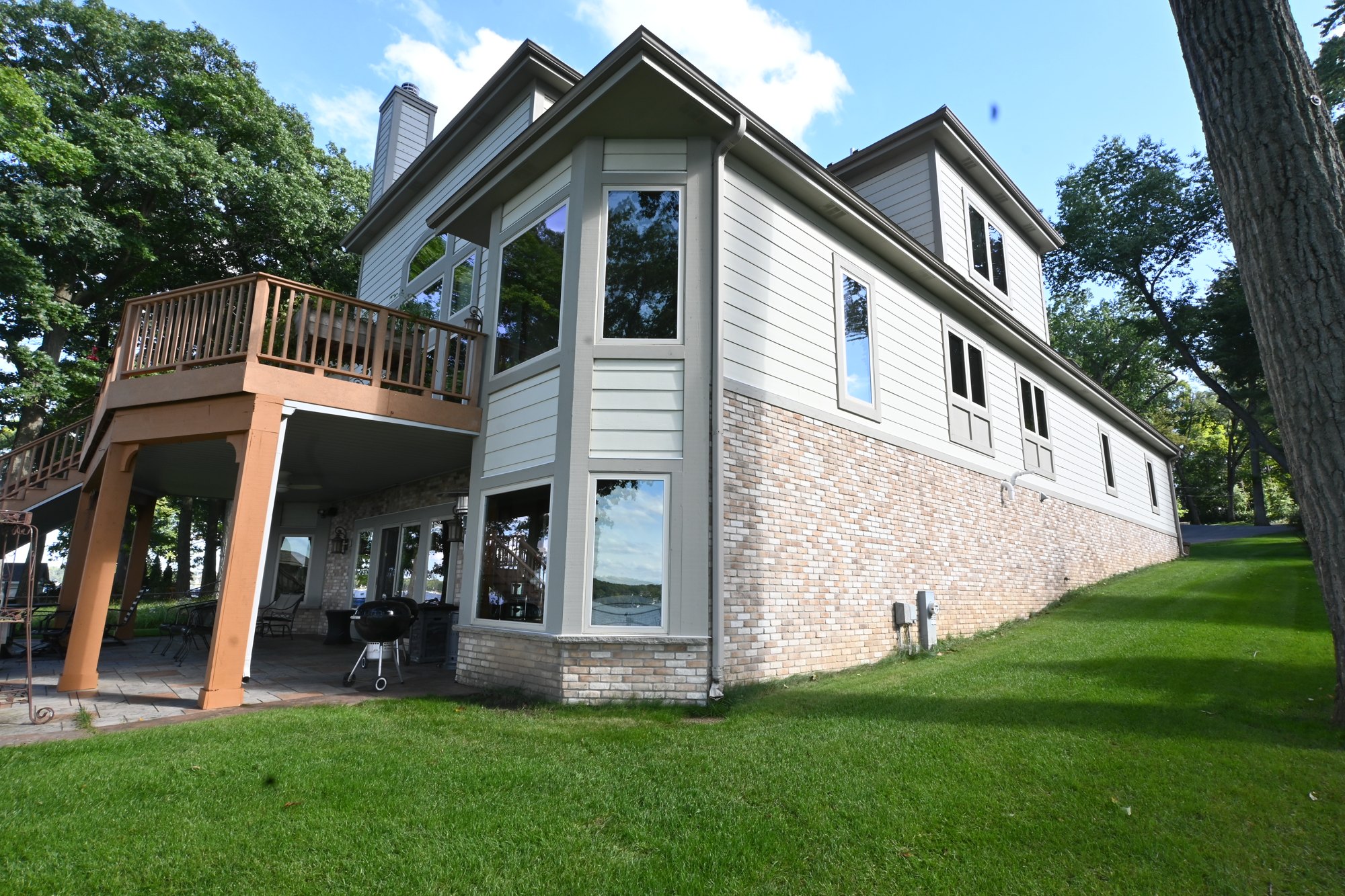 Pewaukee lake home with freshly painted light siding and window trim