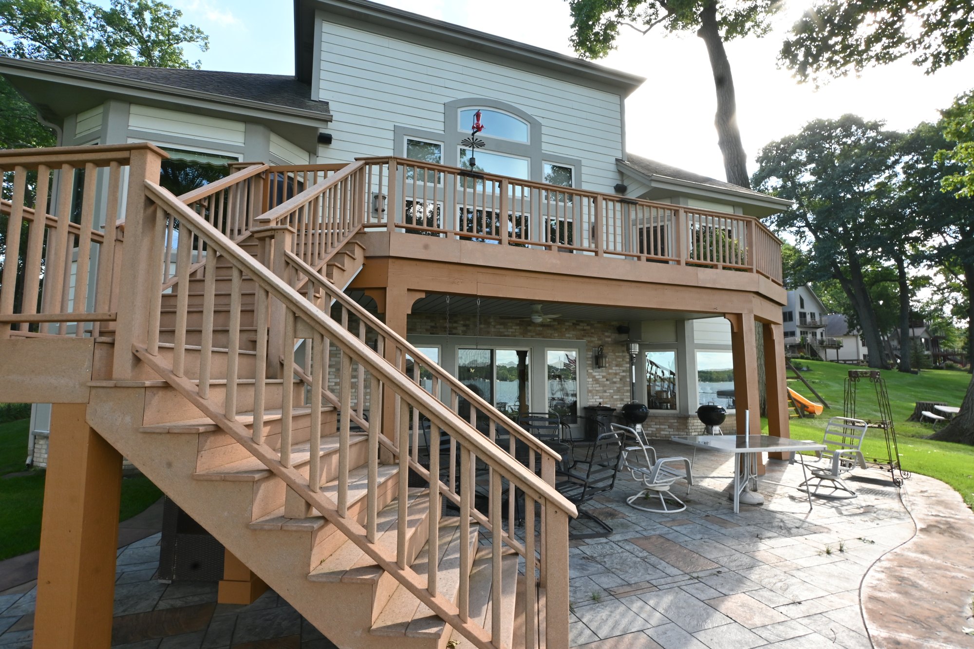 Angled backyard view of the Pewaukee home showing painted siding around the deck
