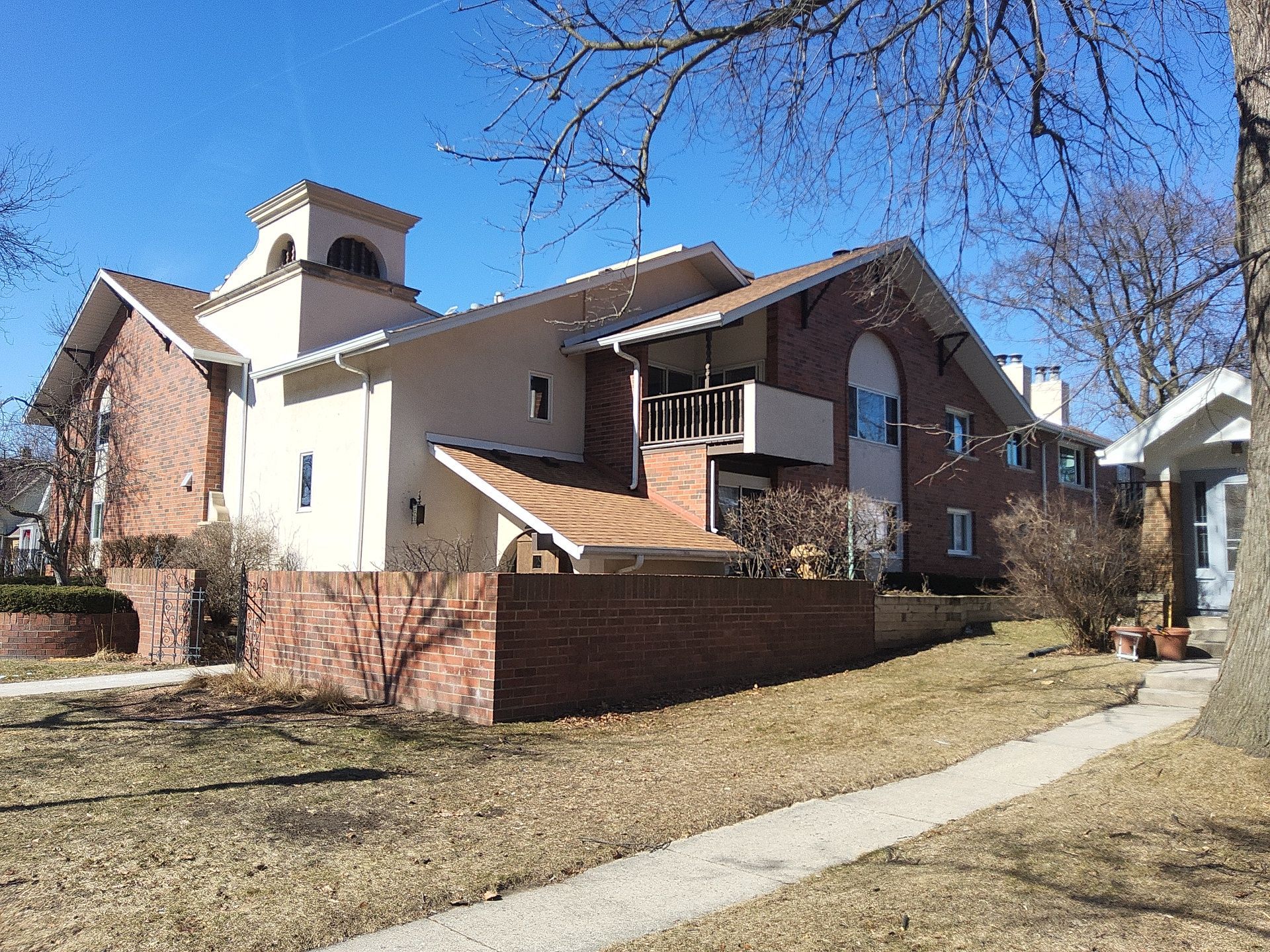 Whitefish Bay apartment building after an Empire Painting project, with light exterior walls and brick accents