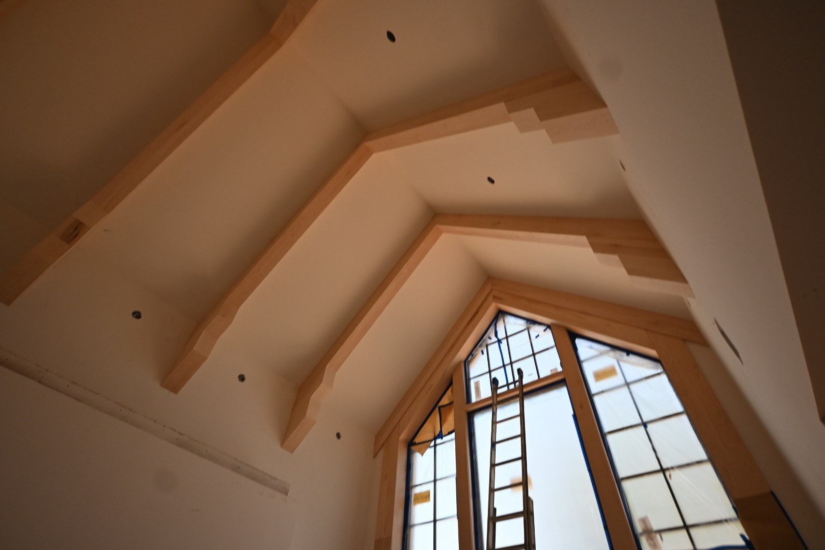 Wood ceiling beams and light painted surfaces in the vaulted interior