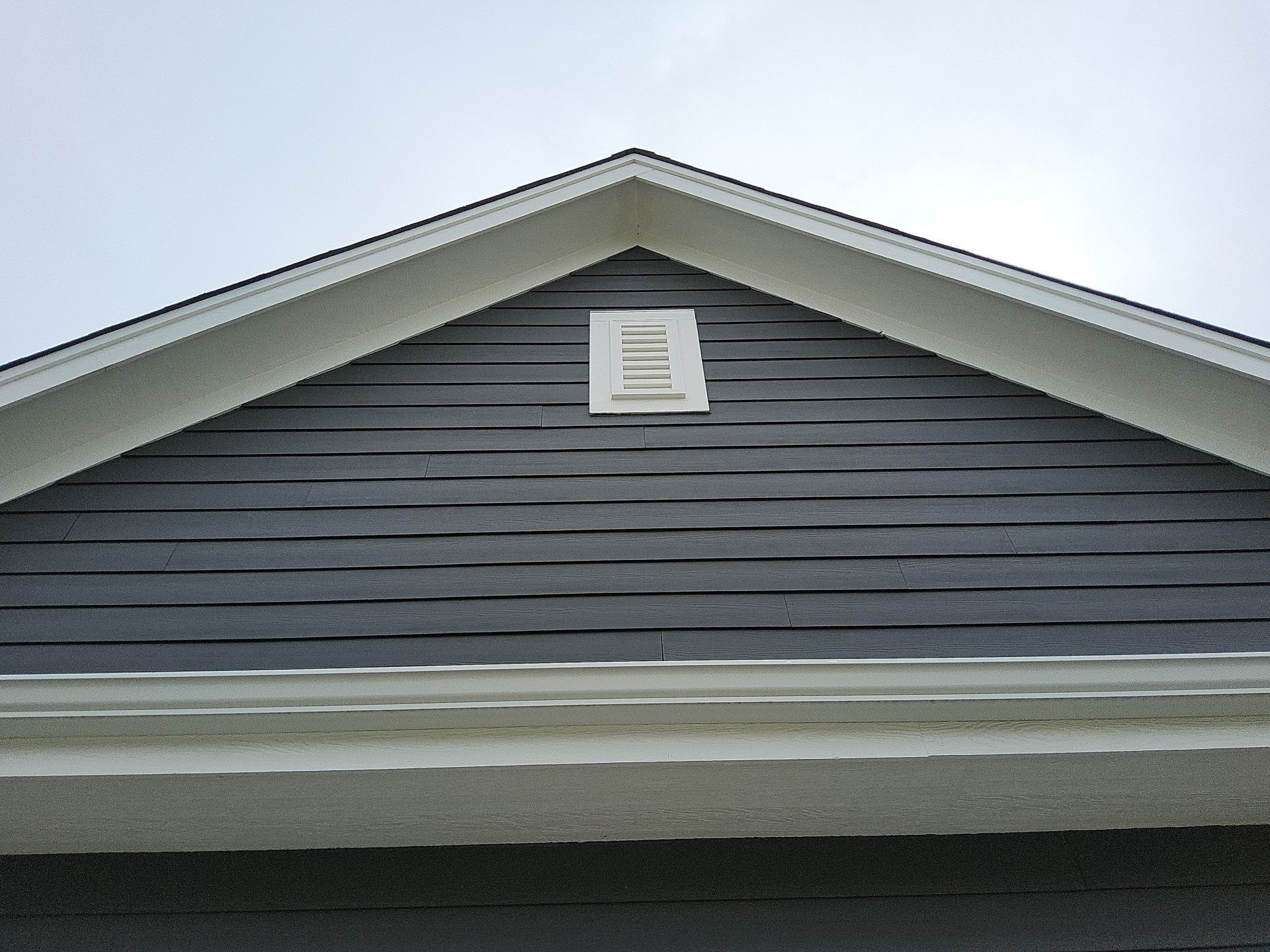 Charcoal front gable with white vent and roofline trim in Wales, Wisconsin