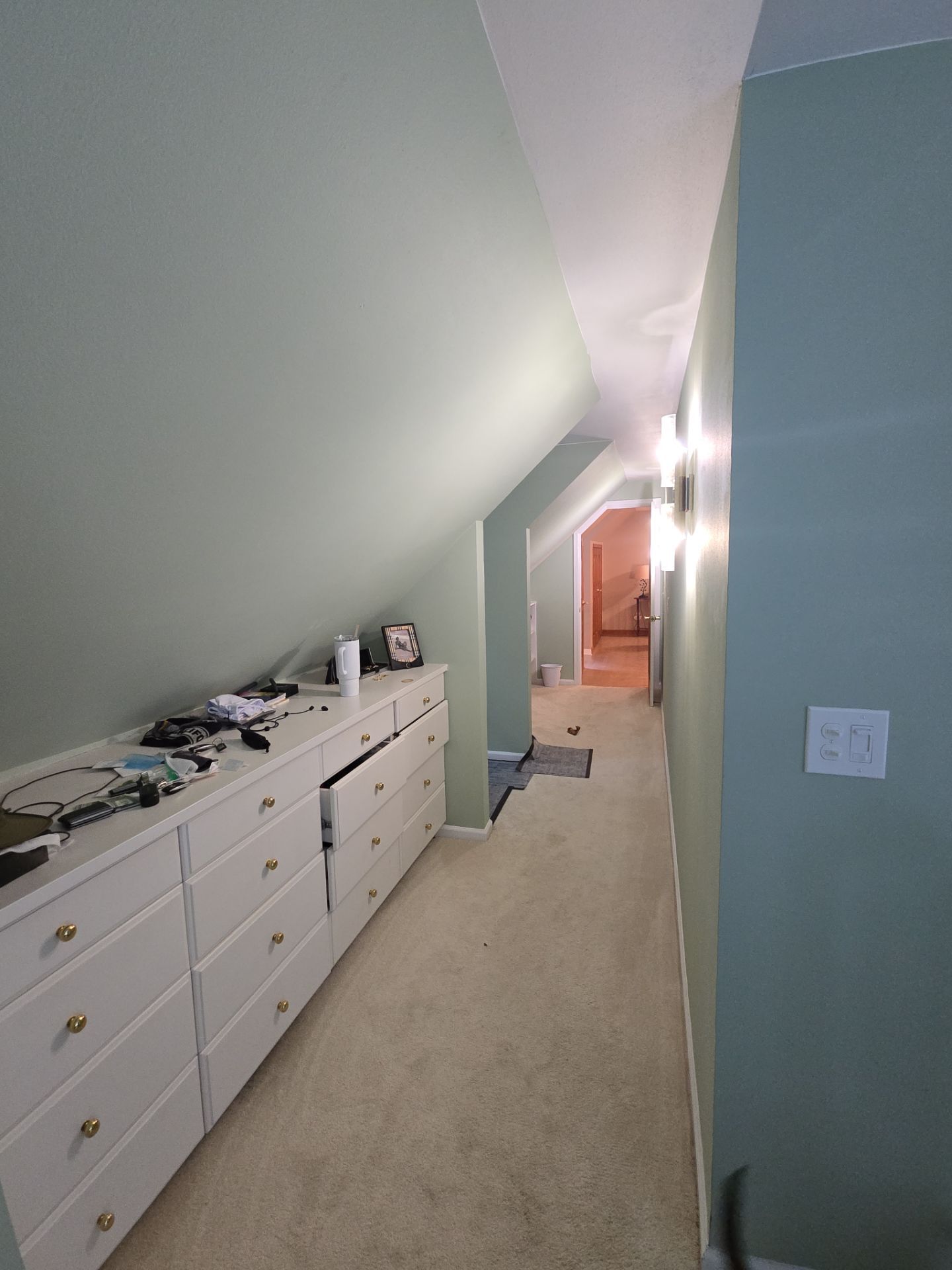 Soft green walls and white trim along a sloped-ceiling hallway in Nashotah