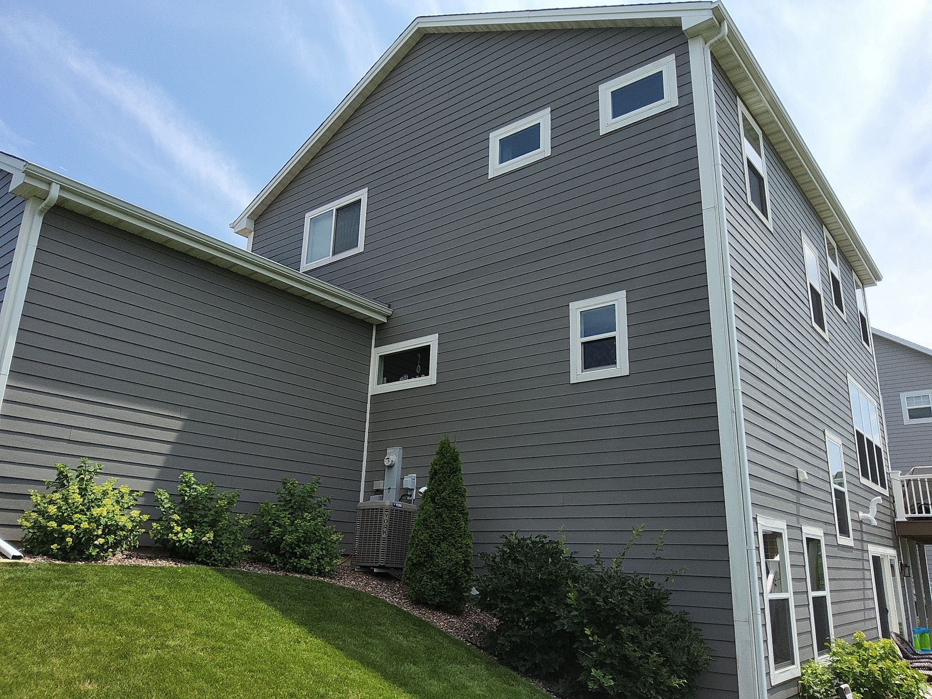 Siding and white window trim along the side of a Menomonee Falls home