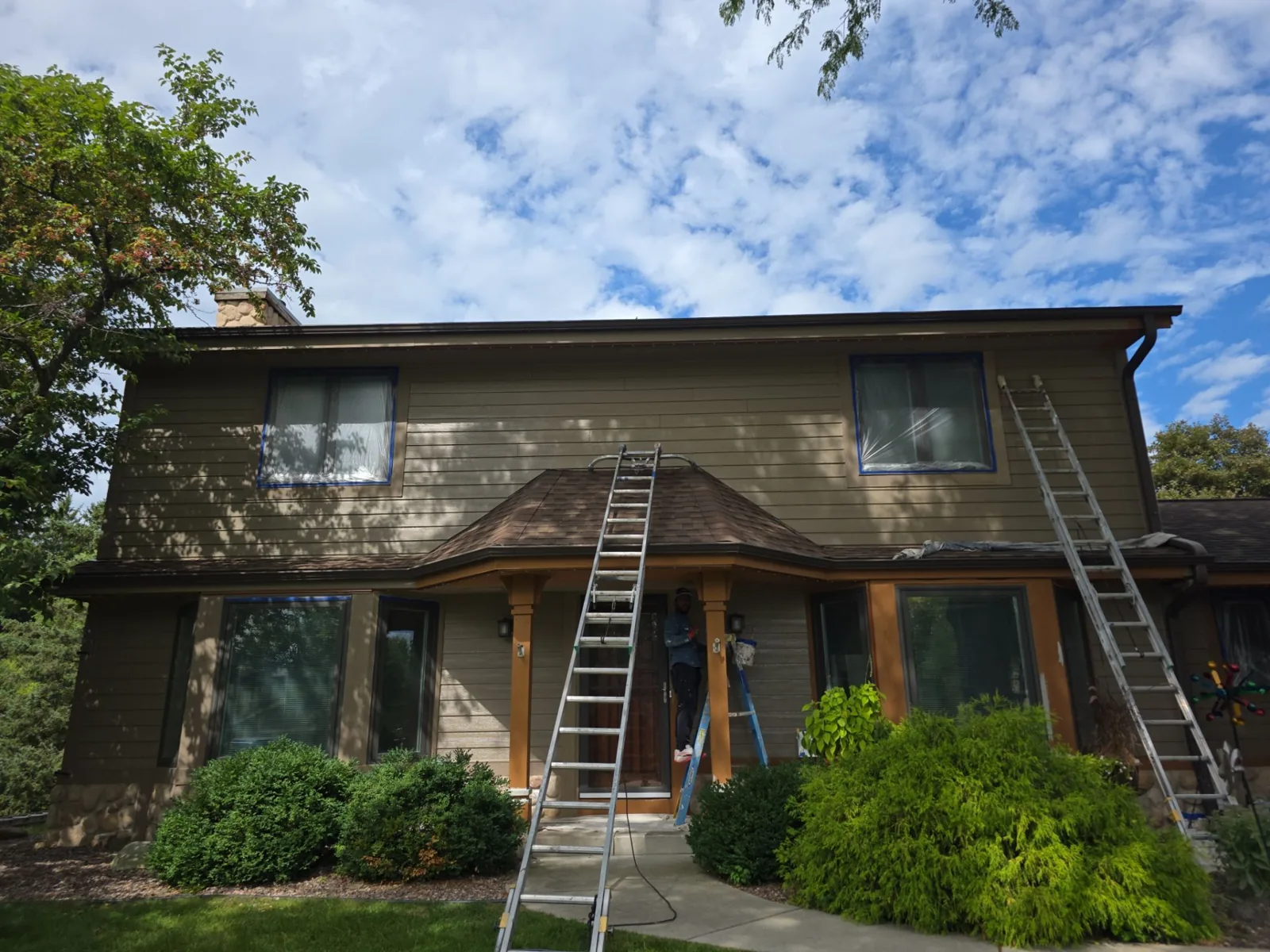 Before: Mequon home with masked windows and ladders during exterior preparation