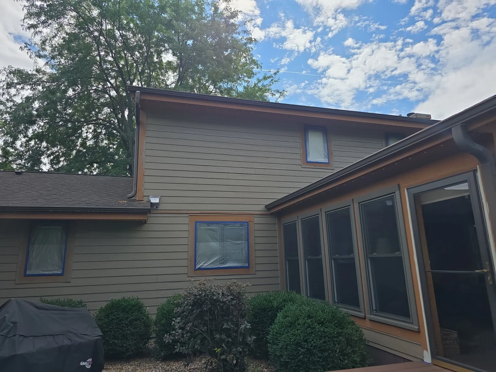 Before: original siding and masked windows beside the screened porch