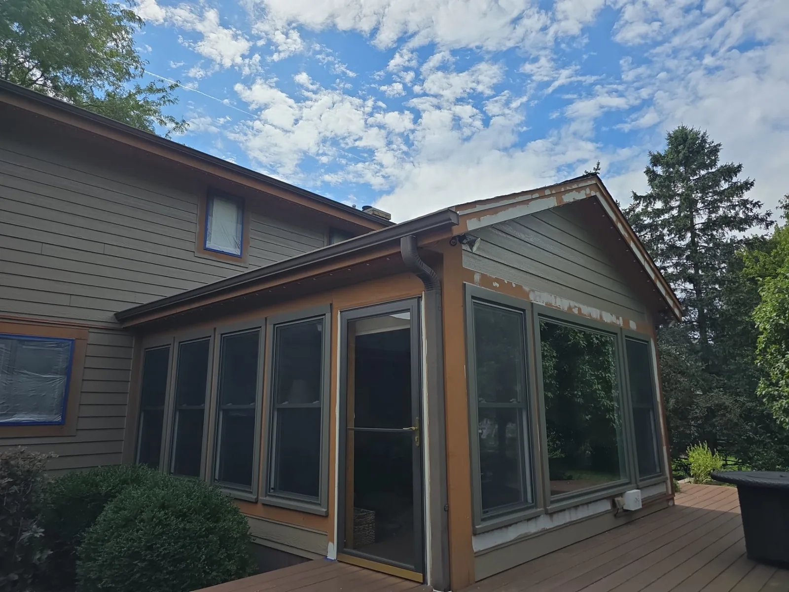 Before: screened porch with scraped trim and protected windows