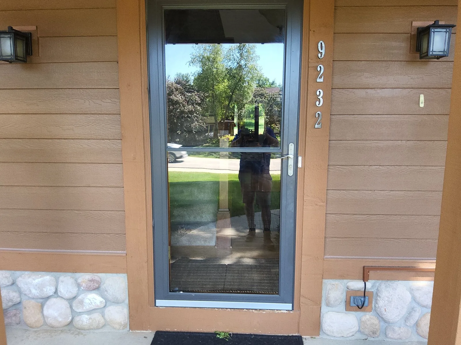 After: warm brown siding and cedar trim around the front entry