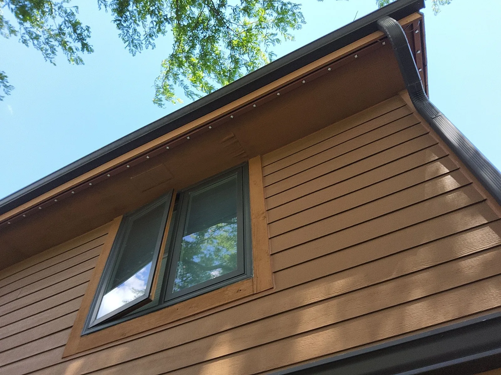 After: upper-story siding, cedar window trim and soffit details