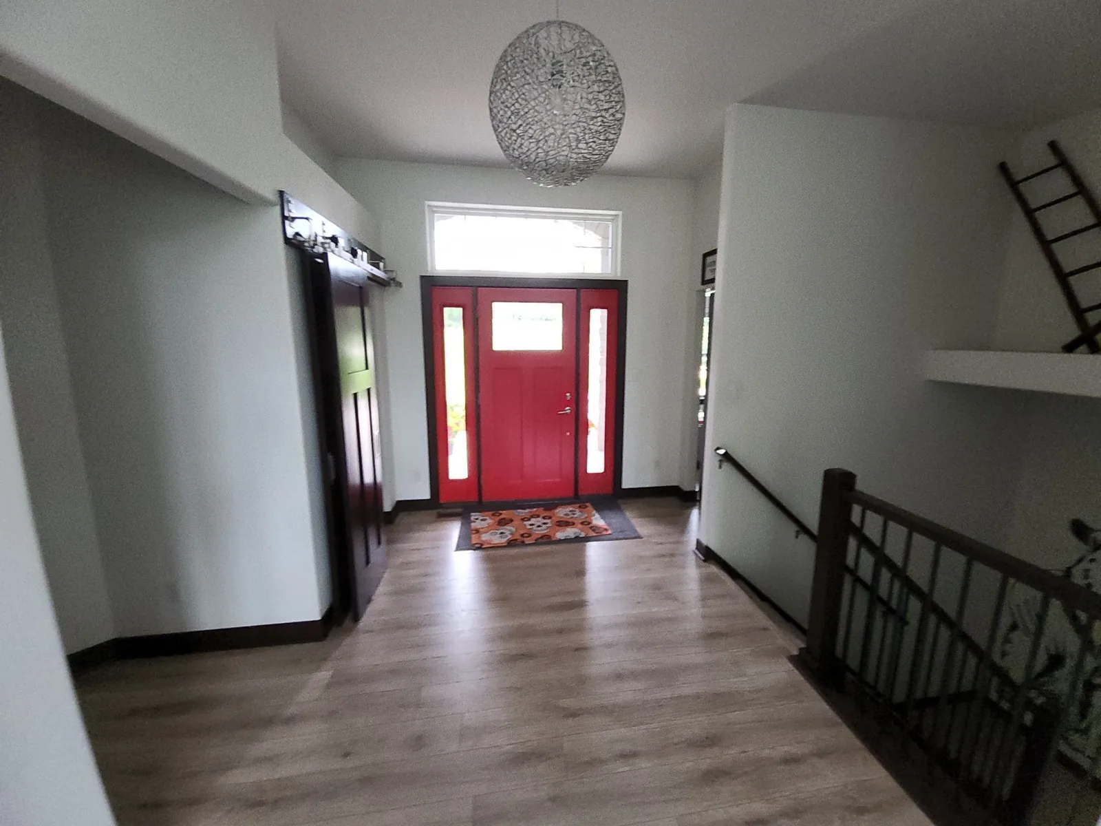 Red entry door with dark trim and light gray painted walls in a New Berlin home