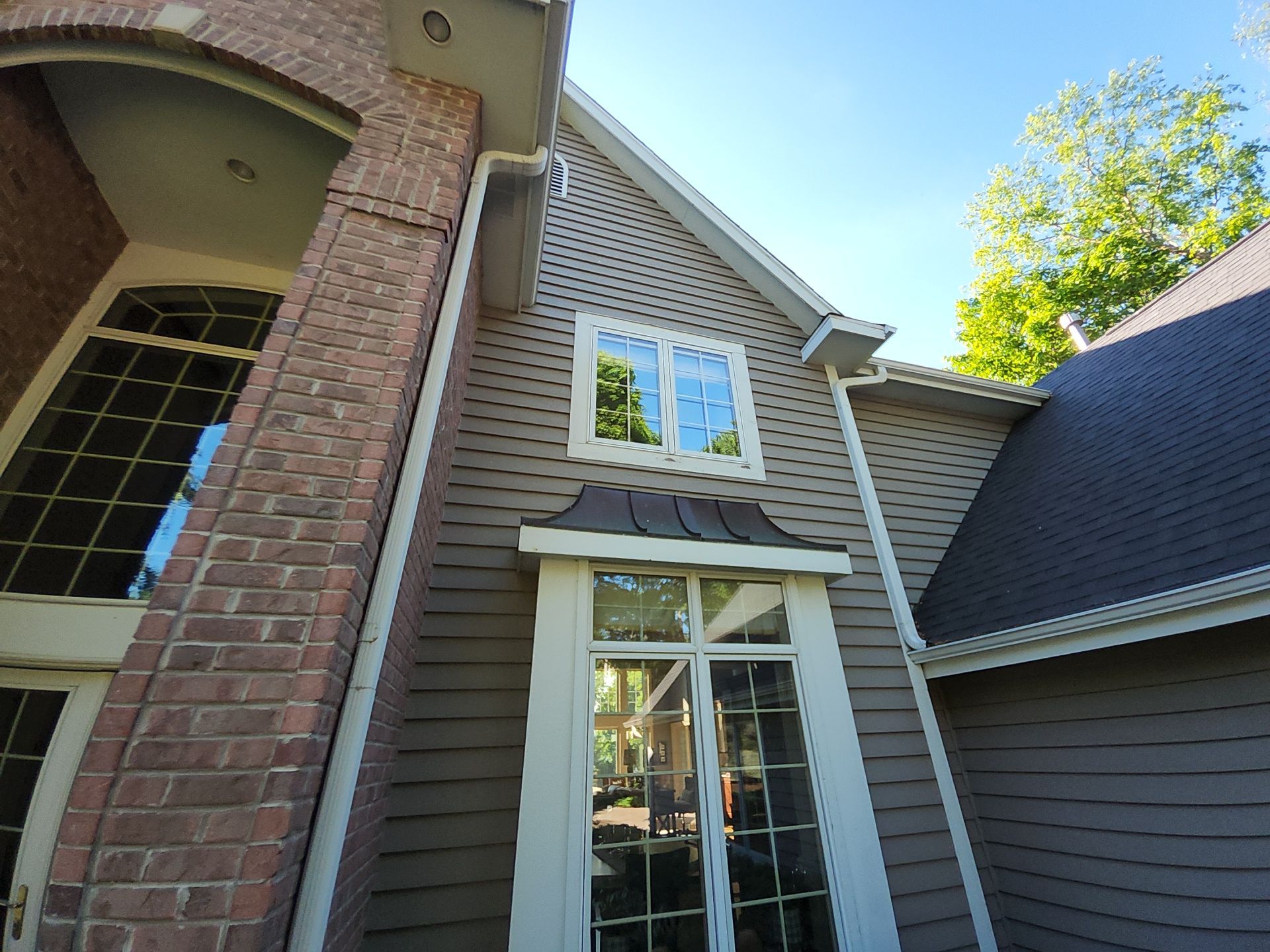 Oconomowoc home with taupe siding and white window trim