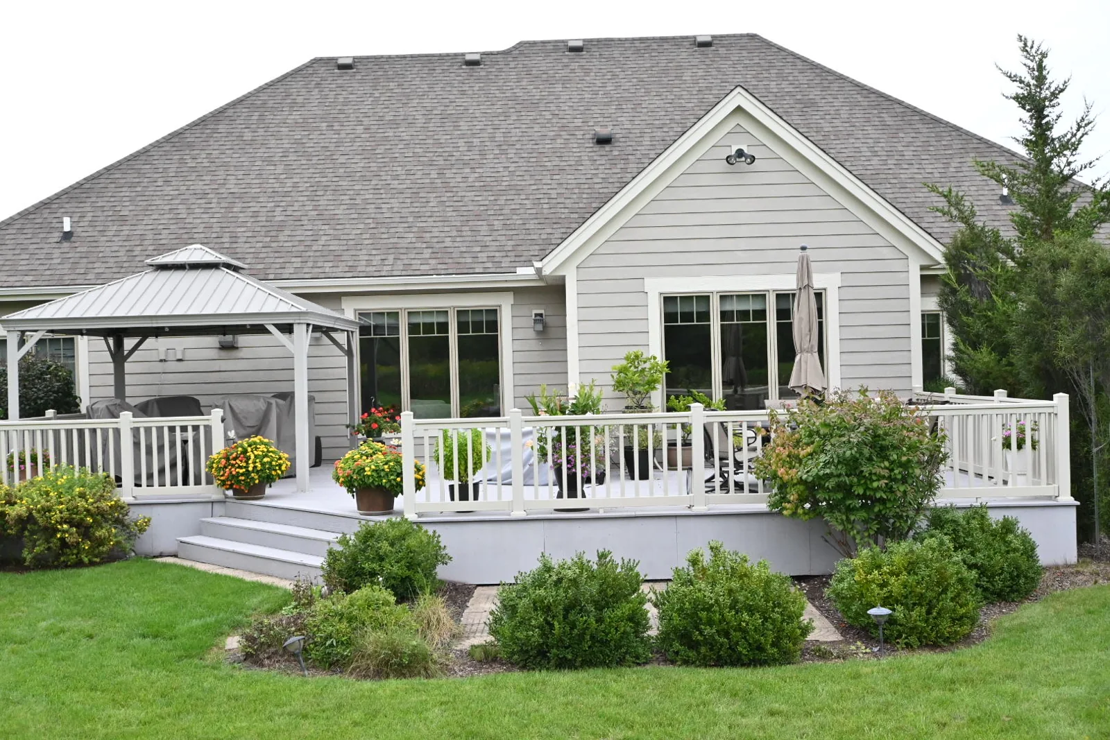 Rear elevation of the repainted Pewaukee home with gray siding and white window trim