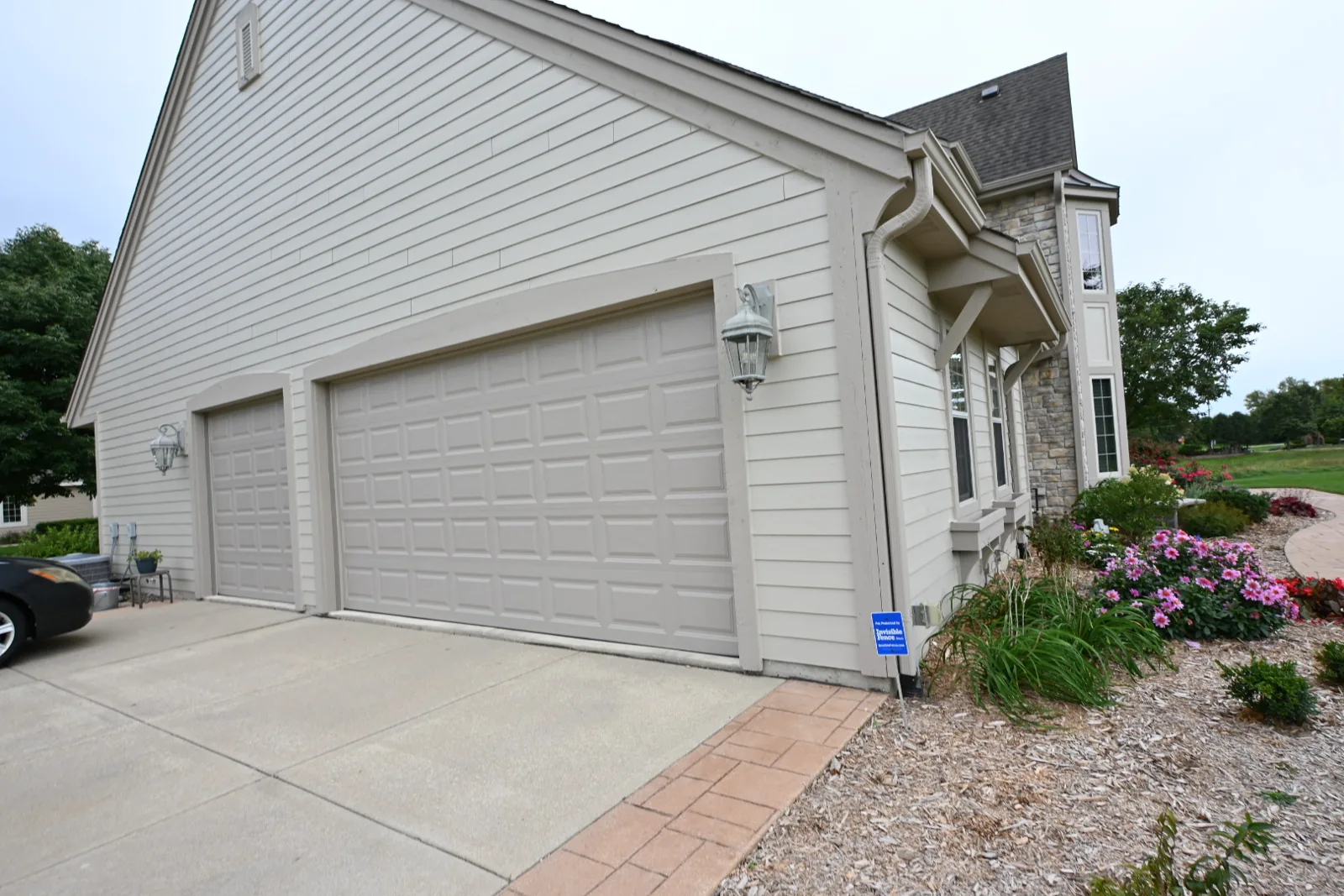 Garage doors and light siding with coordinating trim on a Pewaukee home