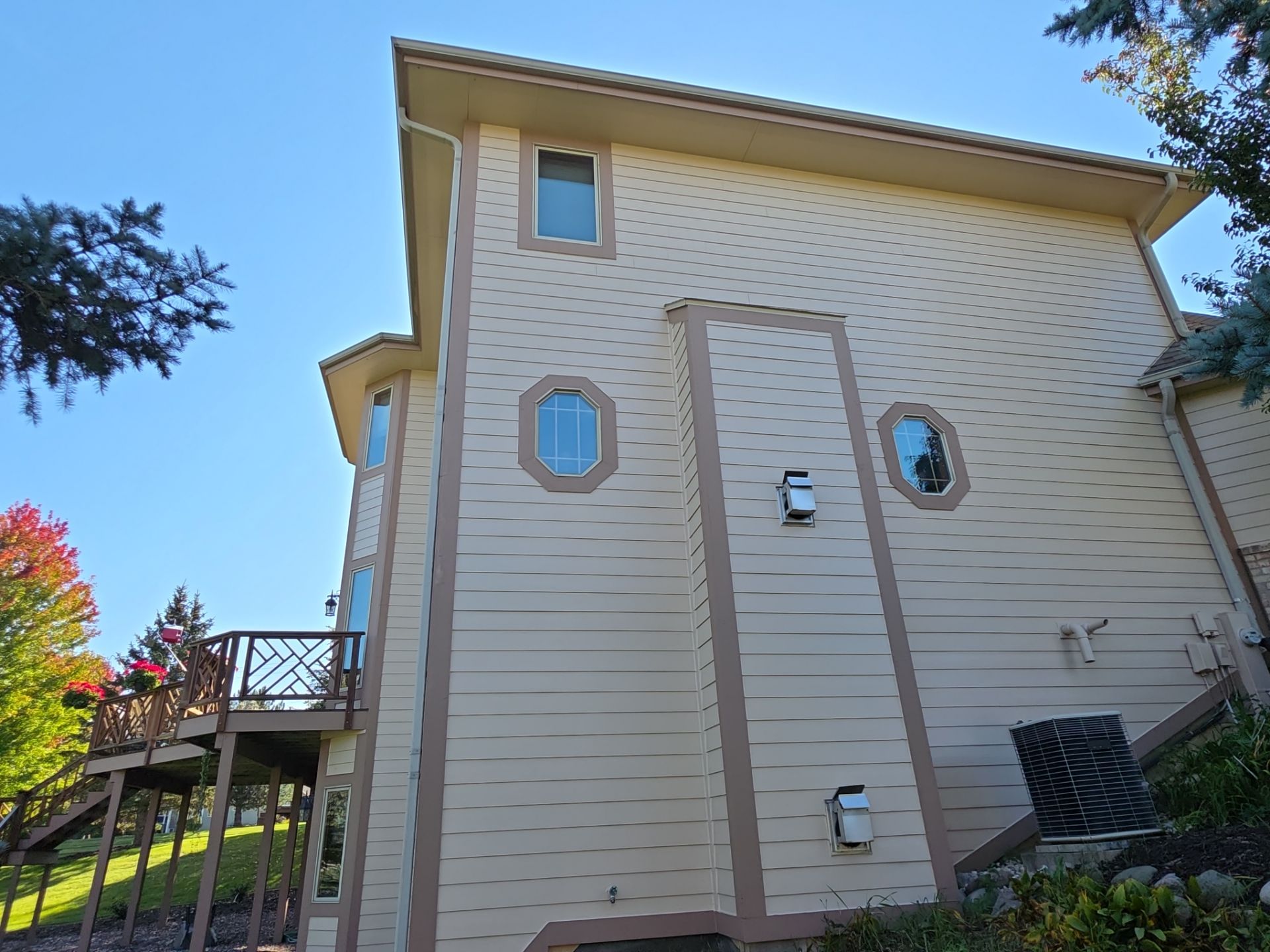 Hartland home side elevation with light siding, contrasting window trim and an elevated deck