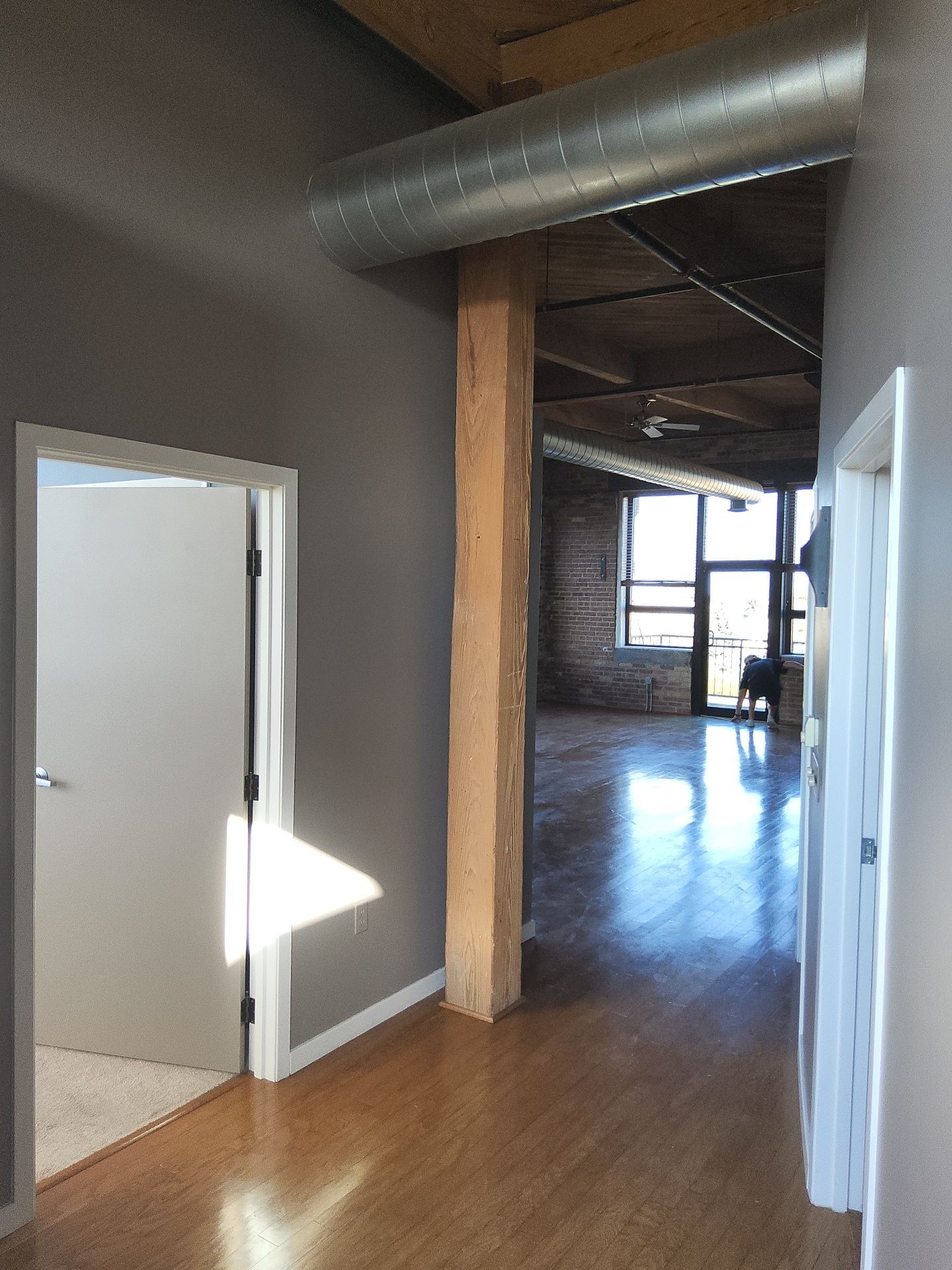Painted hallway and white door trim opening into a Milwaukee loft living area
