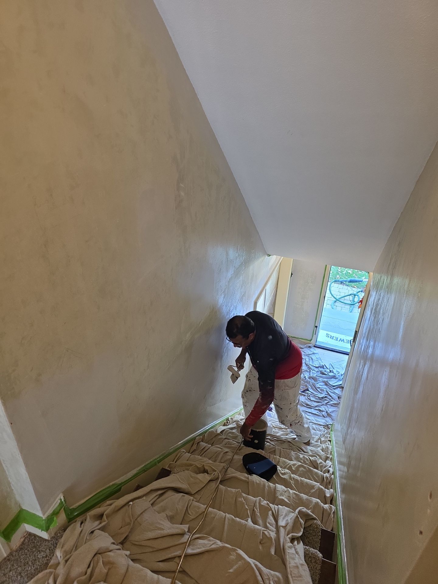 Empire painter preparing Wauwatosa stairway walls with floors protected by drop cloths