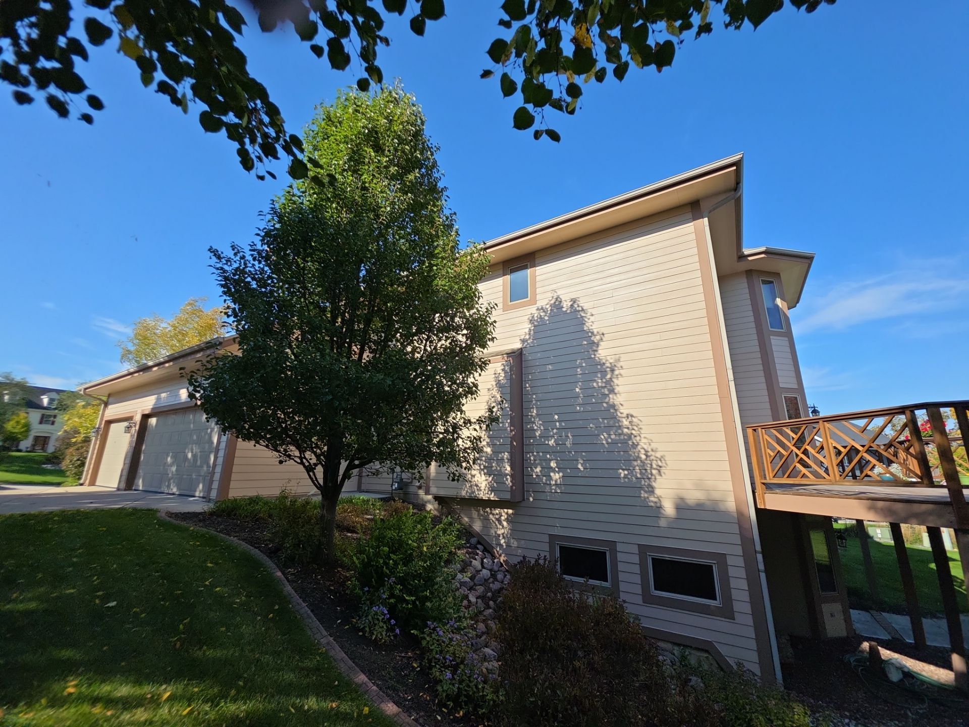 Hartland home side elevation with garage, painted trim and wood railing