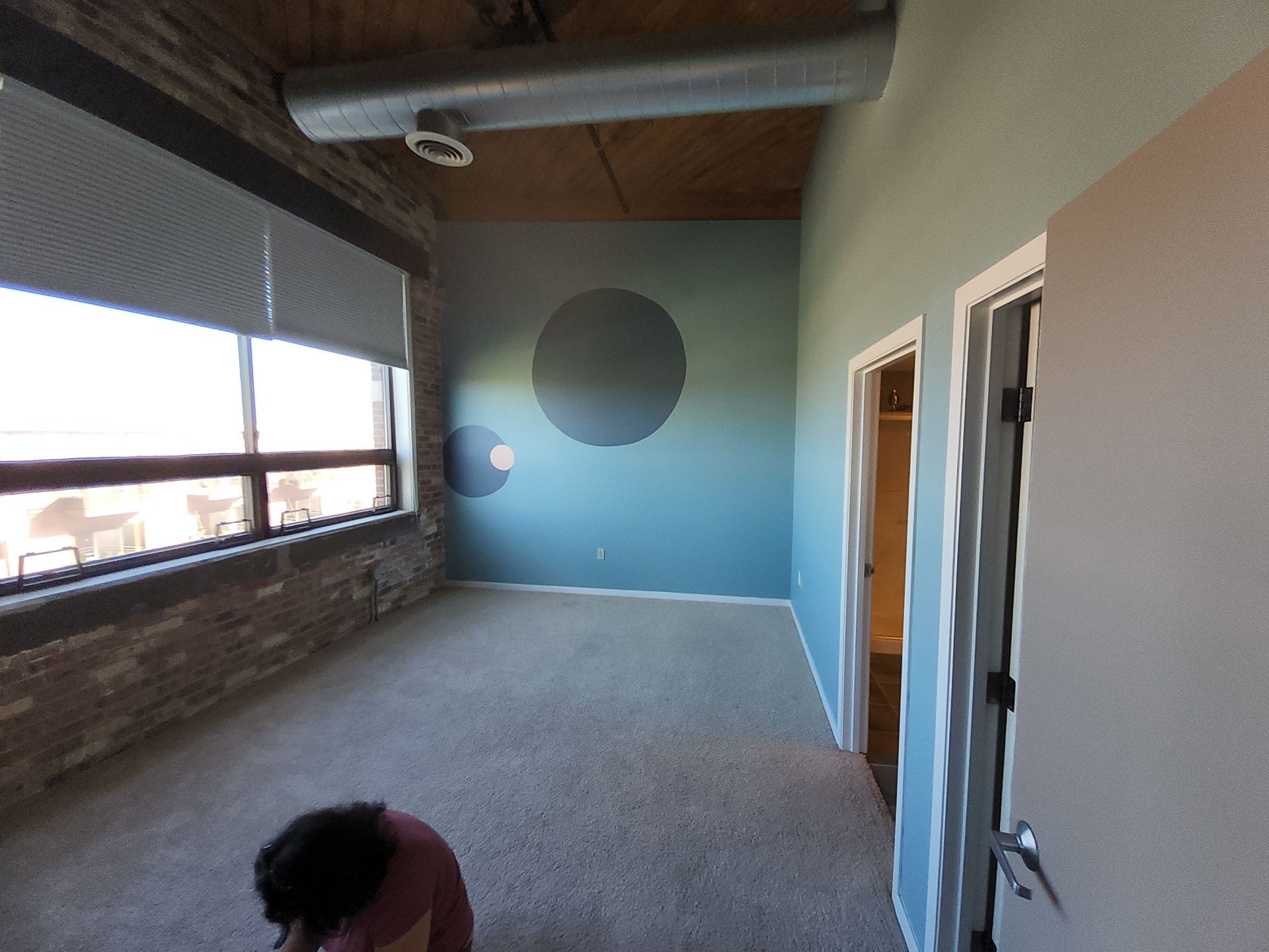 Blue accent wall with circular color details and white door trim