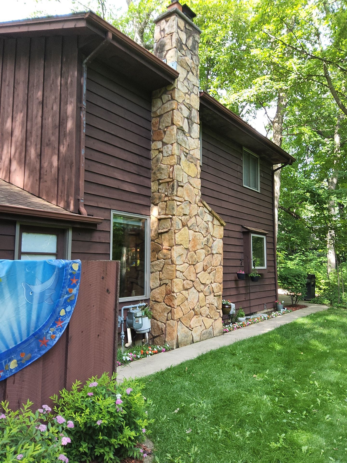 Colgate home exterior before painting with a natural stone chimney