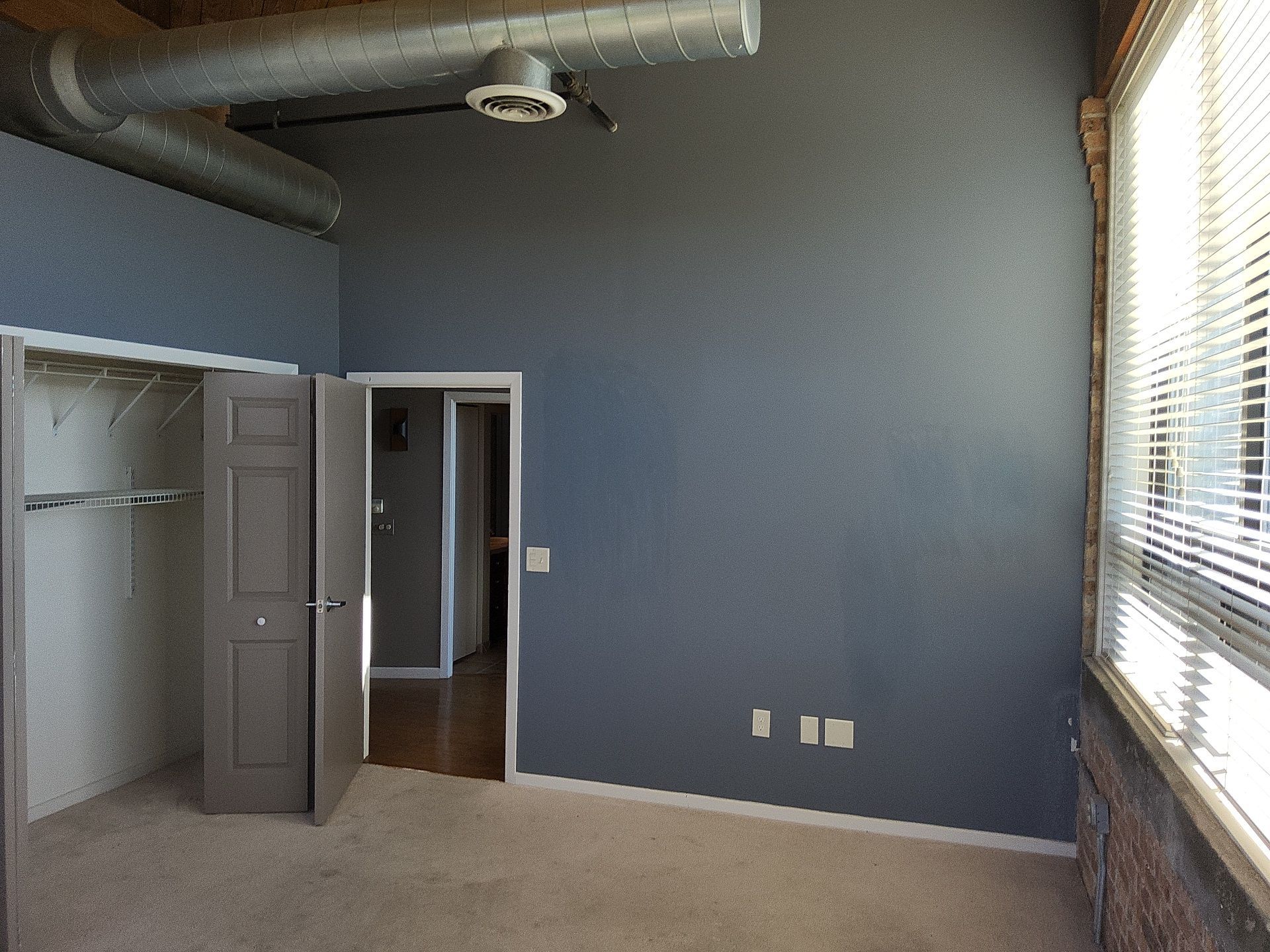 Blue-gray bedroom walls with white trim and gray closet doors