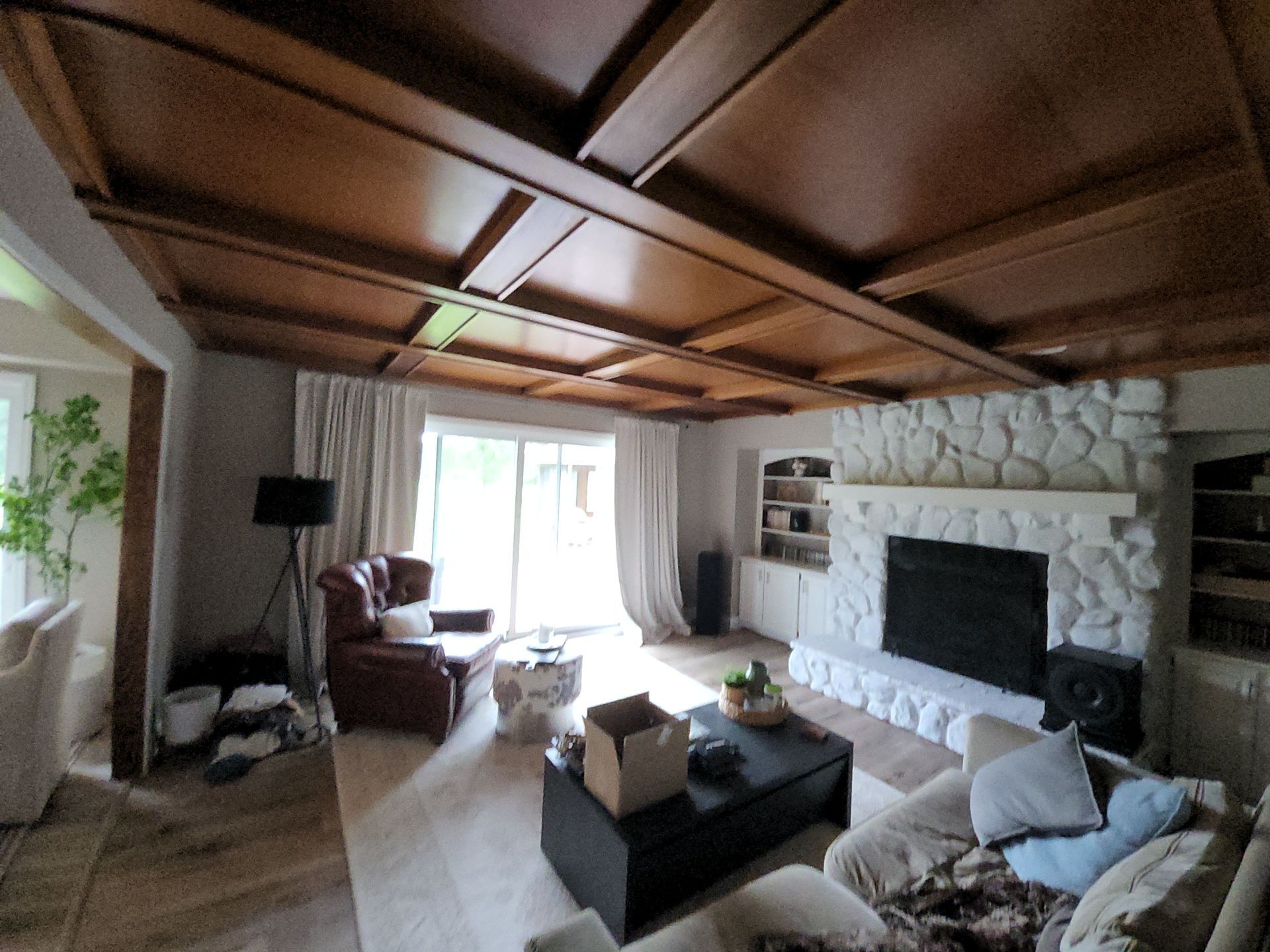 Hartland living room with a wood coffered ceiling, gray walls and a white stone fireplace.